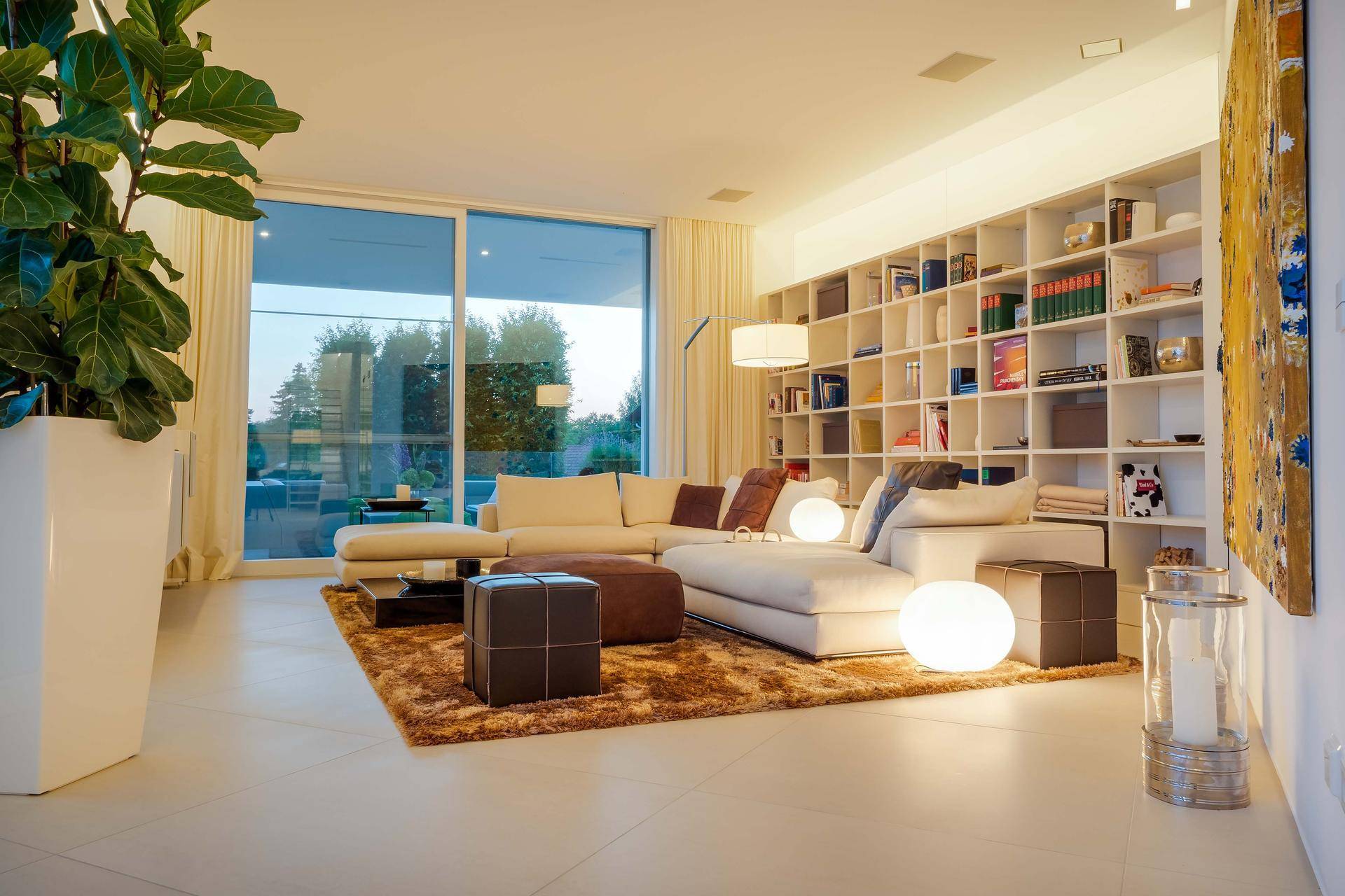 Großzügiges Wohnzimmer mit bequemer Sofalandschaft und einer Bücherwand, die den Raum gemütlich gestaltet.
