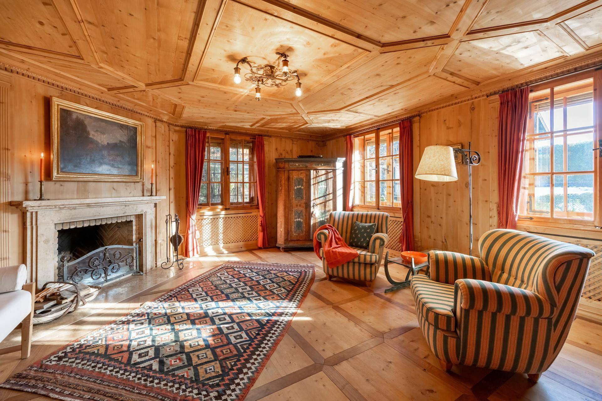 Elegantes Wohnzimmer mit Holztäfelung, Kamin und traditionellen Möbeln.