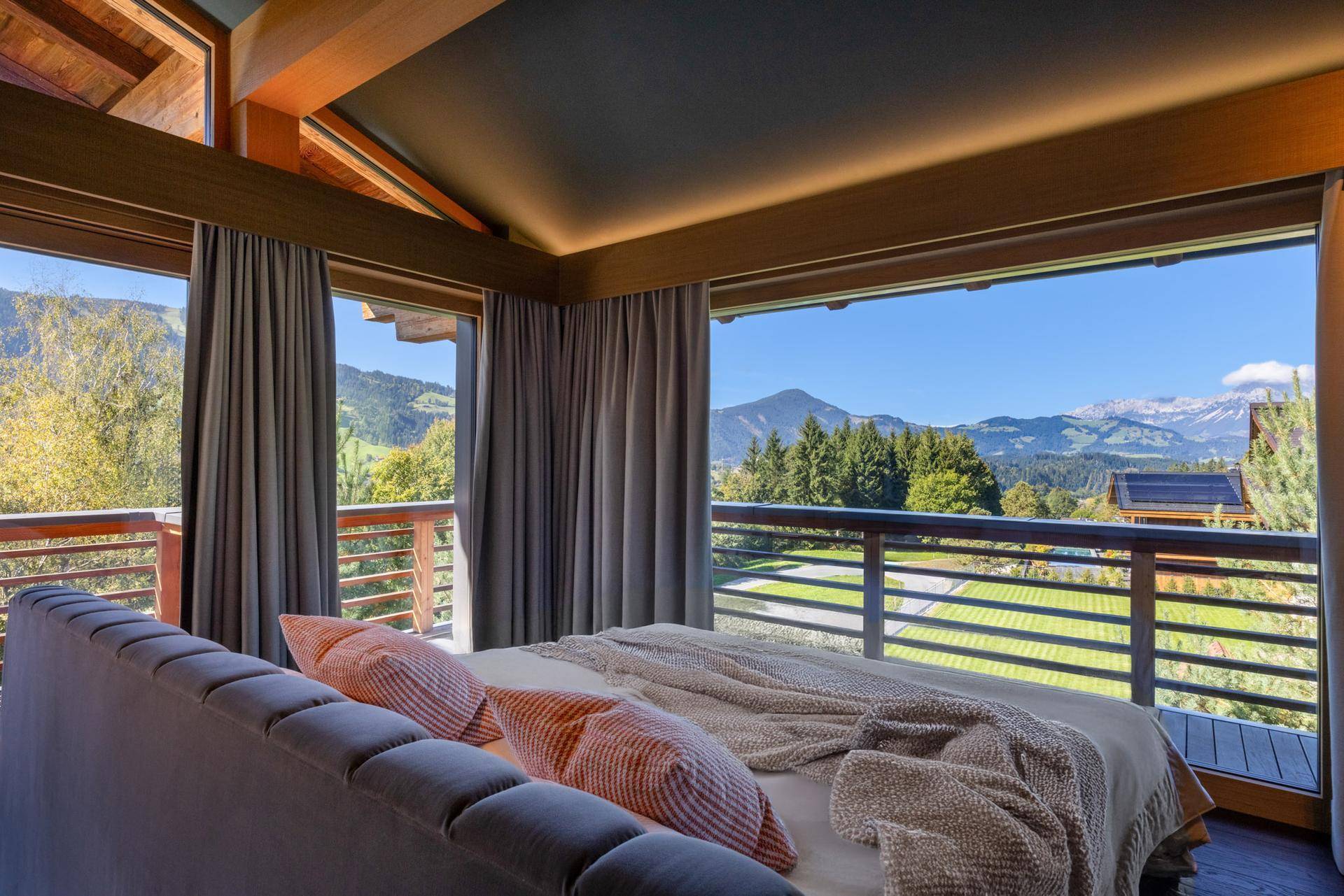 Helles Schlafzimmer mit raumhohen Fenstern, Balkonzugang und spektakulärem Bergblick.