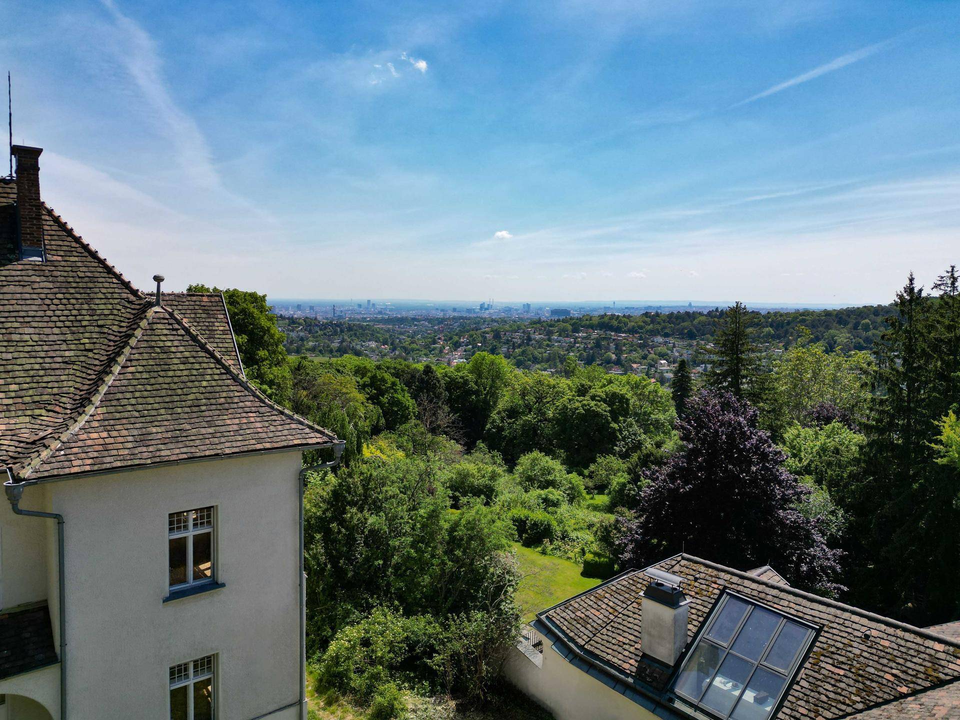 Panoramablick über die Villa und die umliegende grüne Landschaft bis zur Stadt.