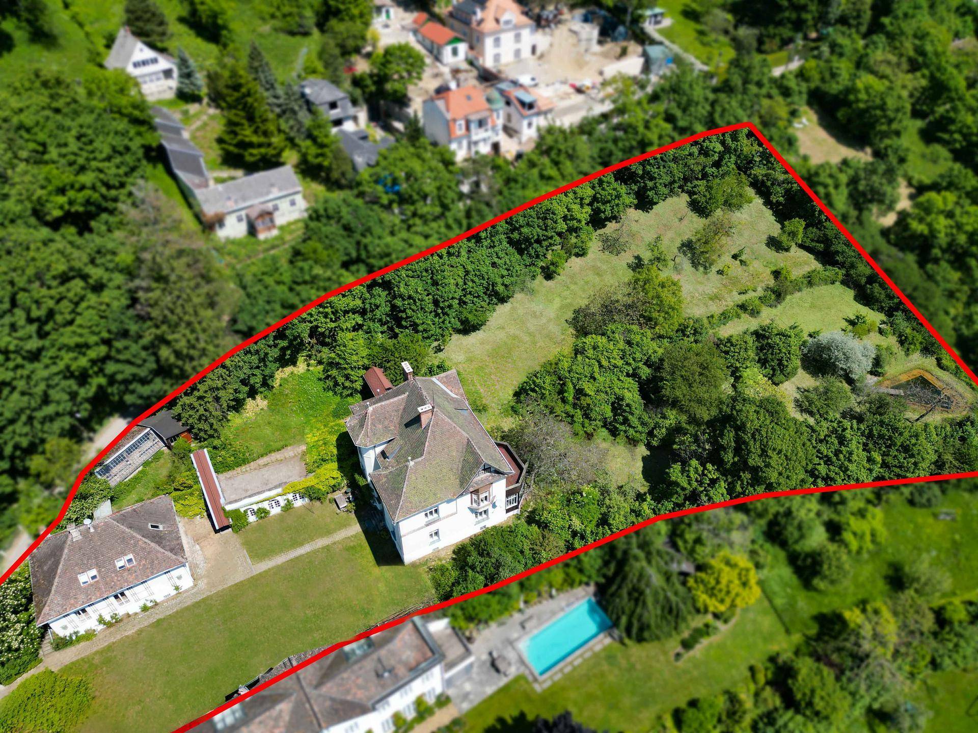 Luftaufnahme des weitläufigen Grundstücks mit Villa, Nebengebäuden und viel Grünfläche.
