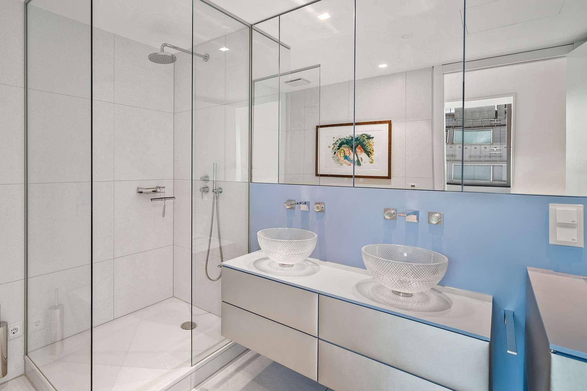 Modernes Badezimmer mit begehbarer Dusche, Doppelwaschbecken und großem Spiegelschrank.