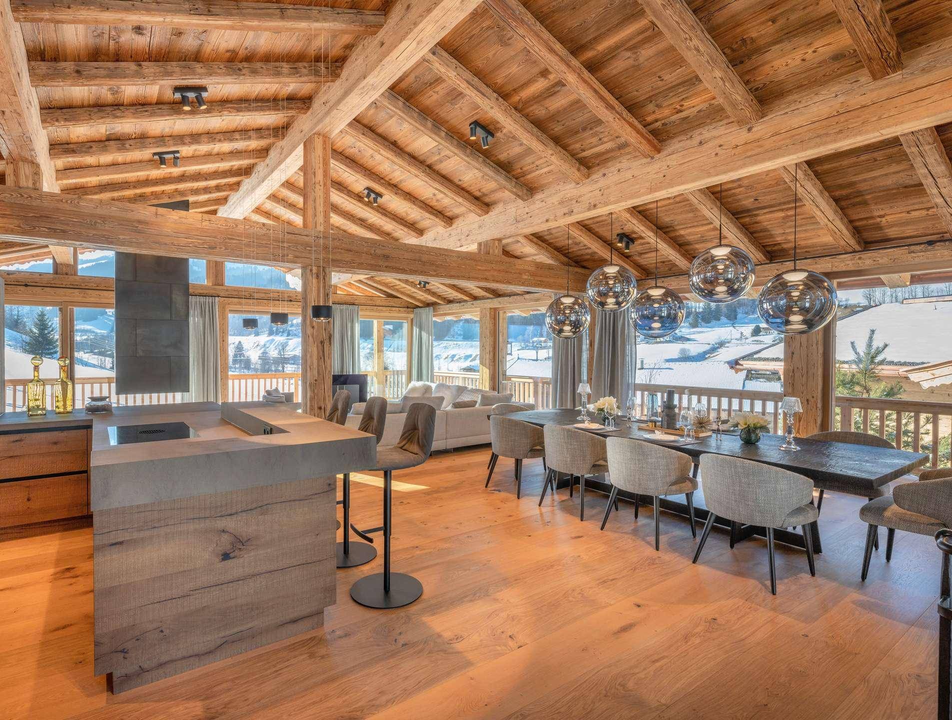 Eleganter Essbereich mit Holzboden, moderner Küche und großen Fenstern mit malerischem Ausblick.