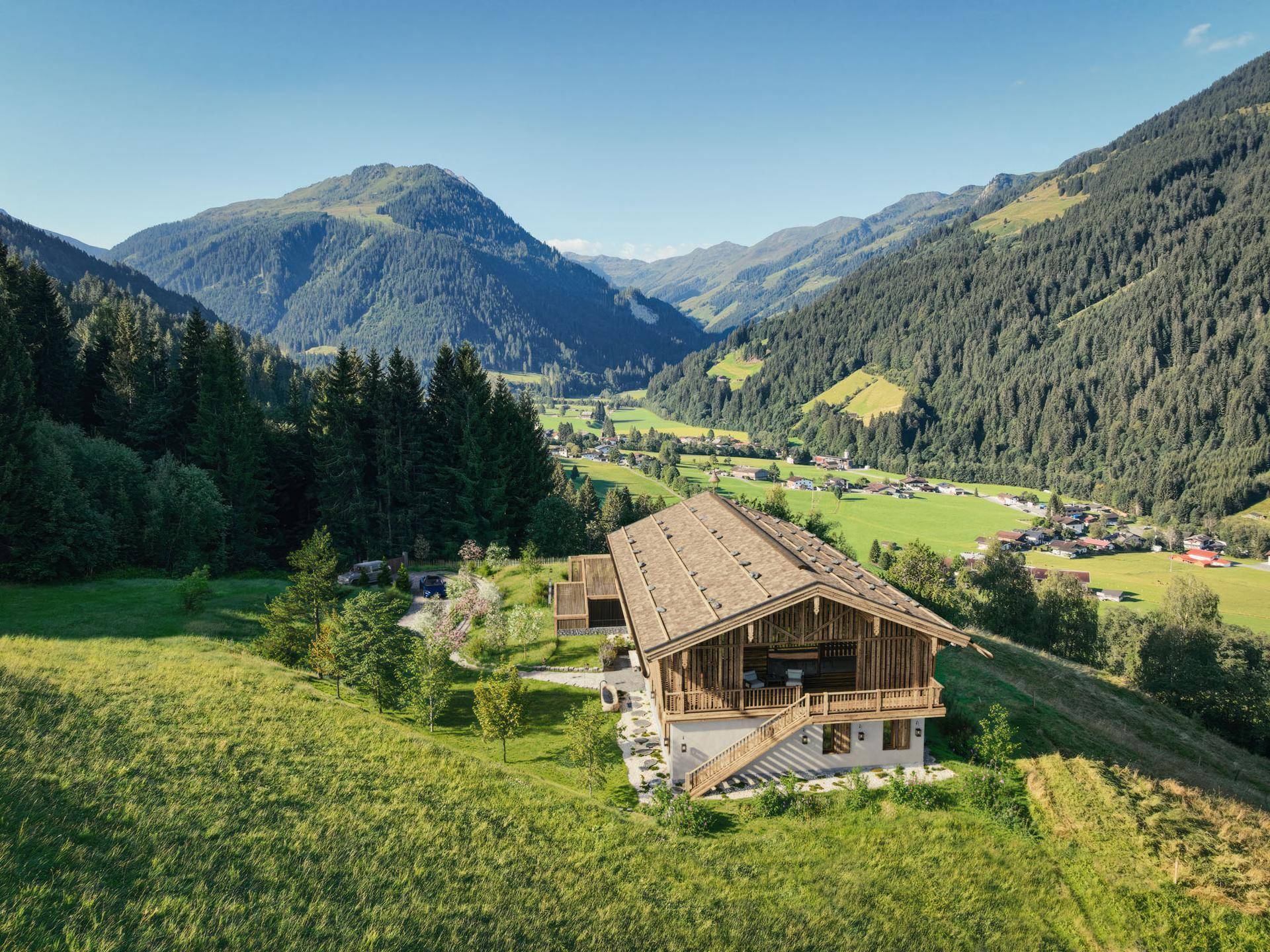 Chalet in Hanglage mit weitem Blick über das Tal und die umliegende Berglandschaft.