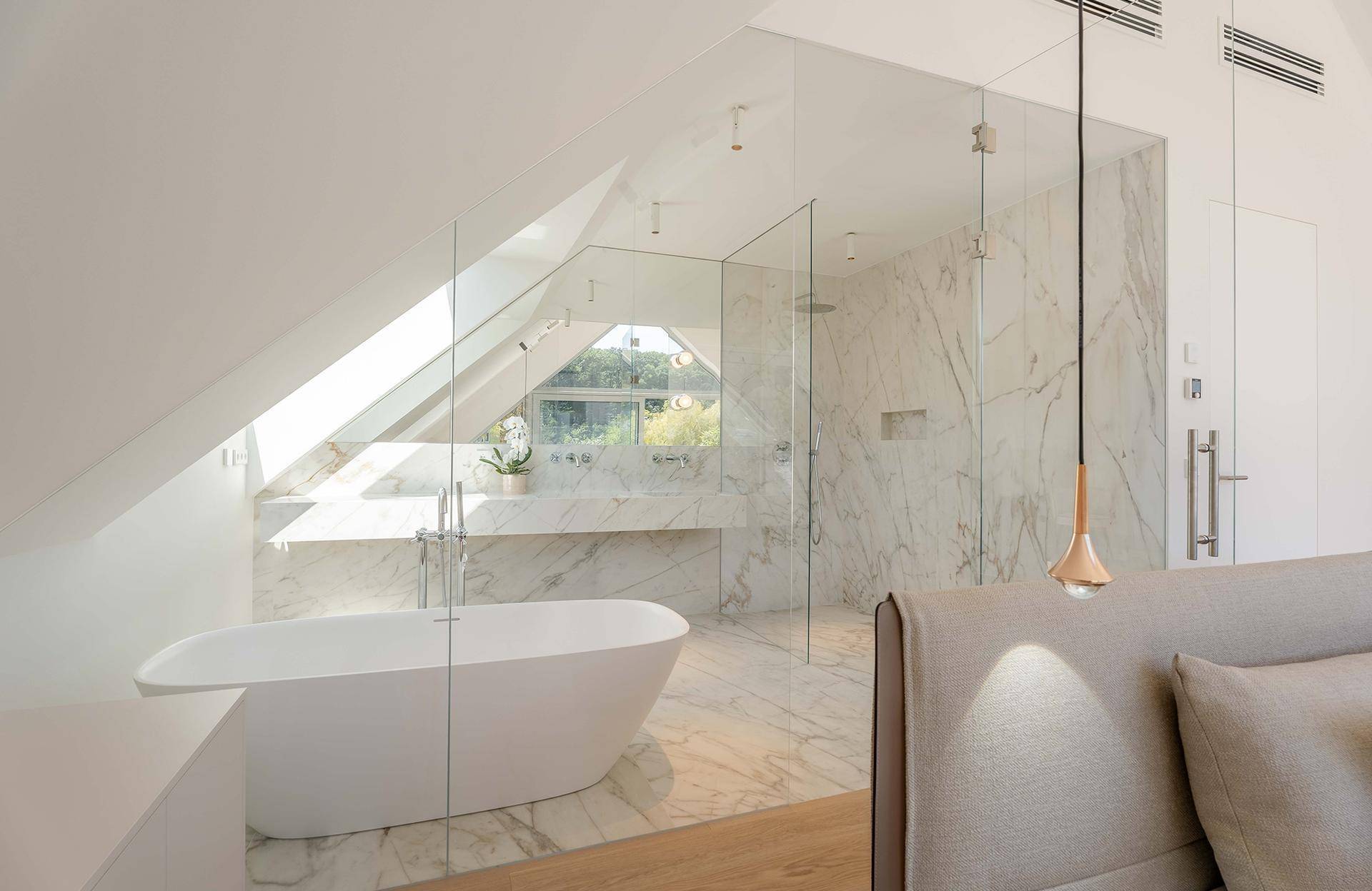 Luxuriöses Badezimmer im Dachgeschoss mit freistehender Badewanne, begehbarer Dusche und Marmorfliesen.