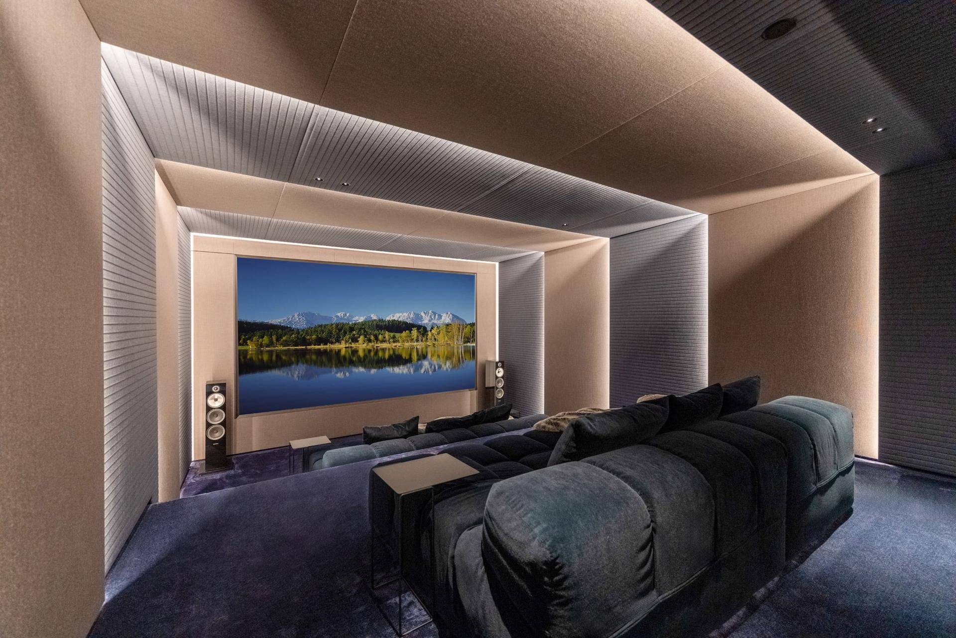 Modernes Heimkino mit großer Leinwand, bequemen Sofas und akustisch optimierter Raumgestaltung.