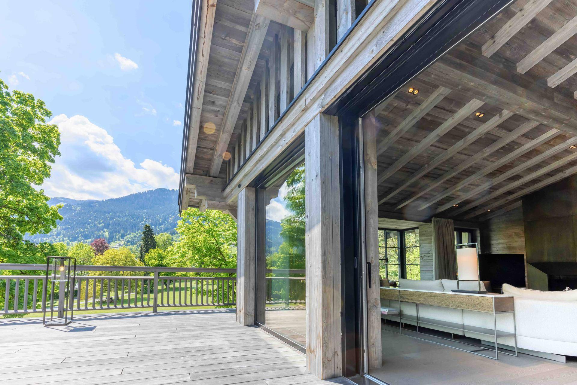 Große Holzterrasse mit Bergblick und direktem Zugang zum Wohnbereich.