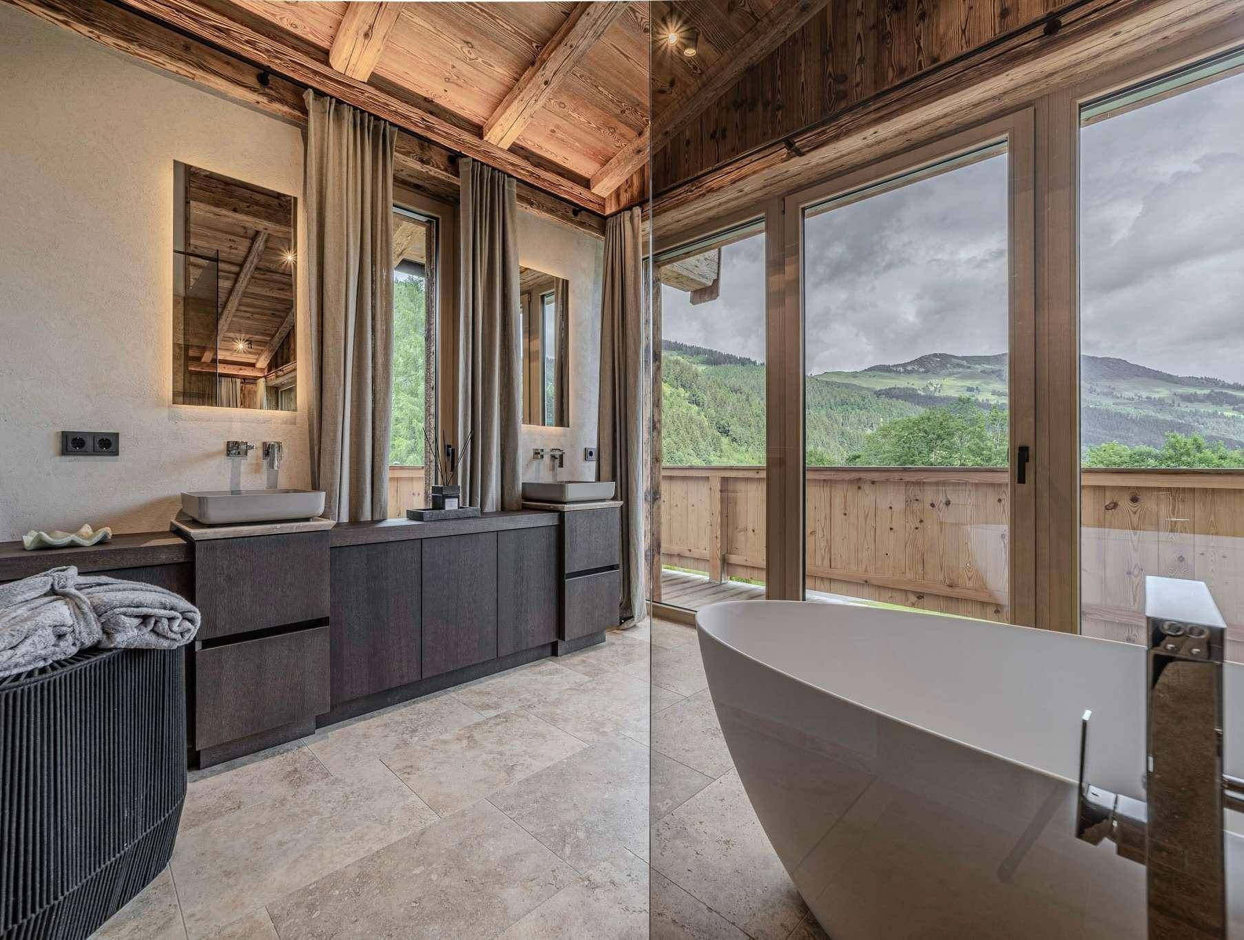 Modernes Badezimmer mit freistehender Badewanne, Doppelwaschbecken und Bergblick.