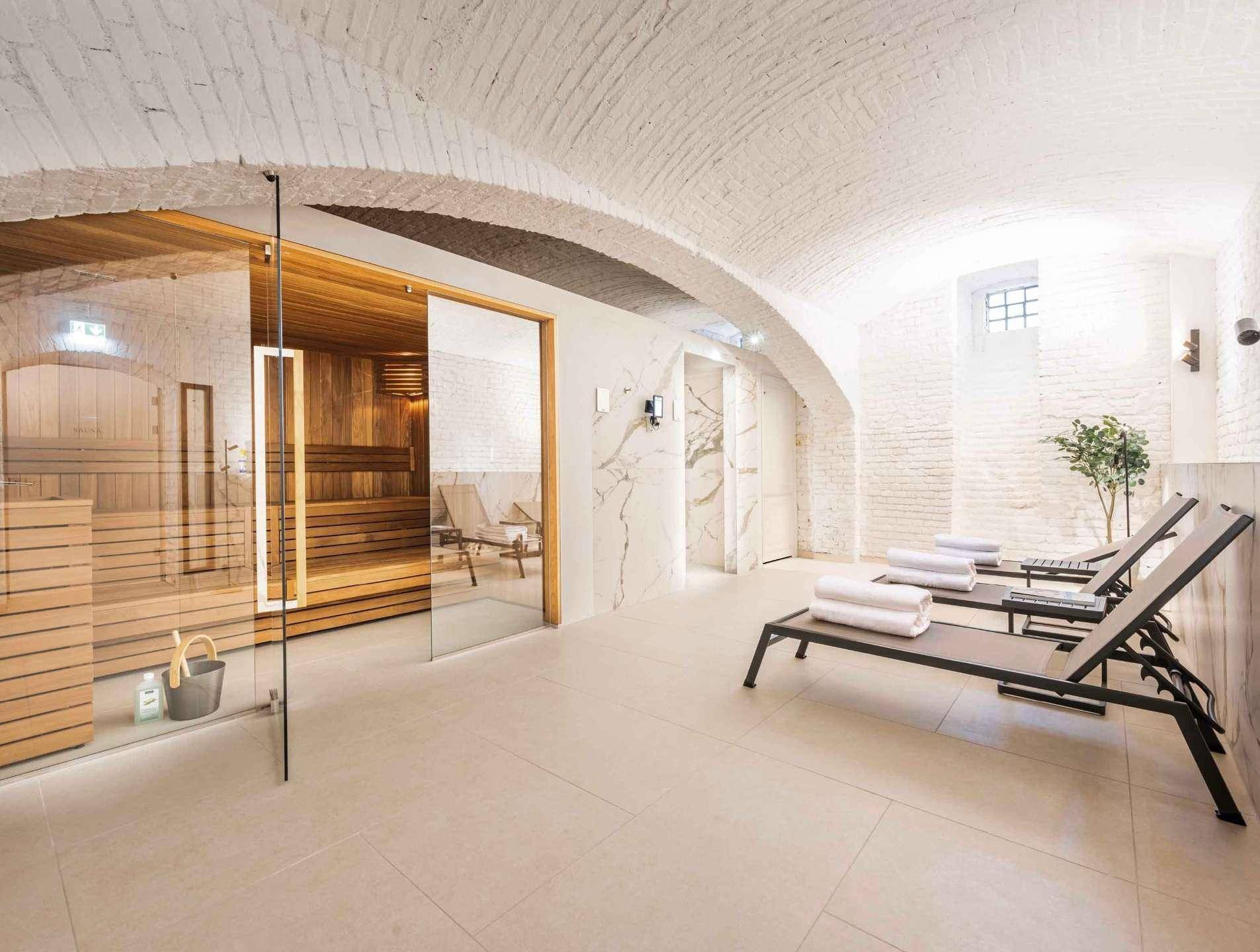 Exklusiver Wellnessbereich mit Sauna, Liegestühlen und beeindruckender Gewölbedecke.