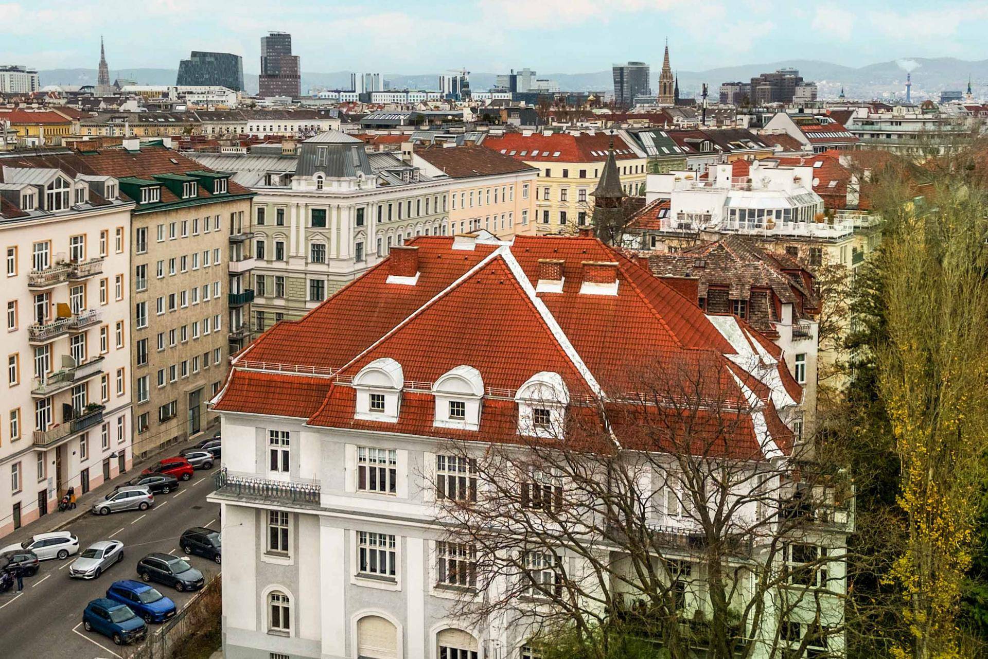 Panoramablick über die Stadt mit historischen Gebäuden und moderner Skyline im Hintergrund.