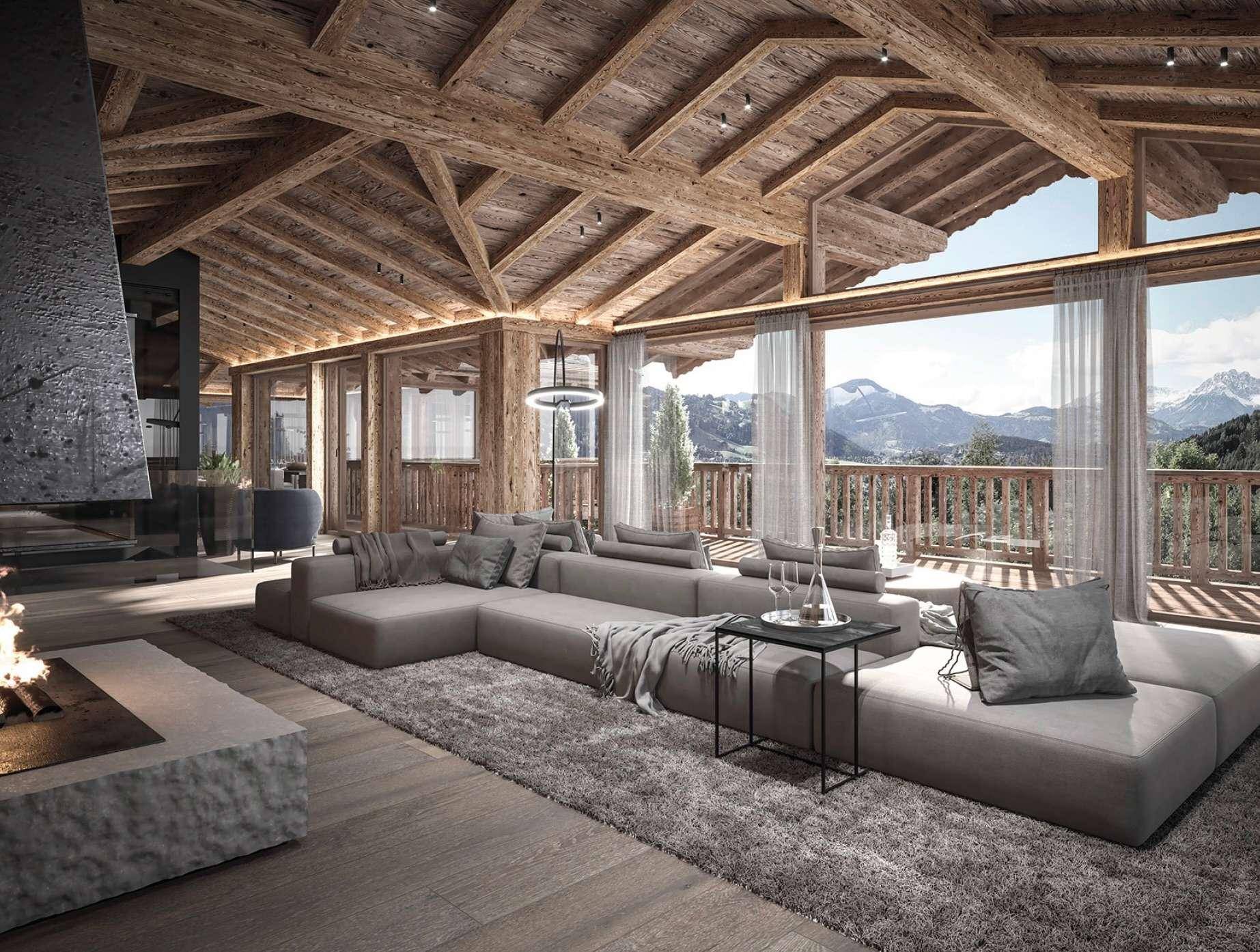 Großzügiges Wohnzimmer mit Holzbalkendecke, Kamin und Panoramafenstern mit Bergblick.