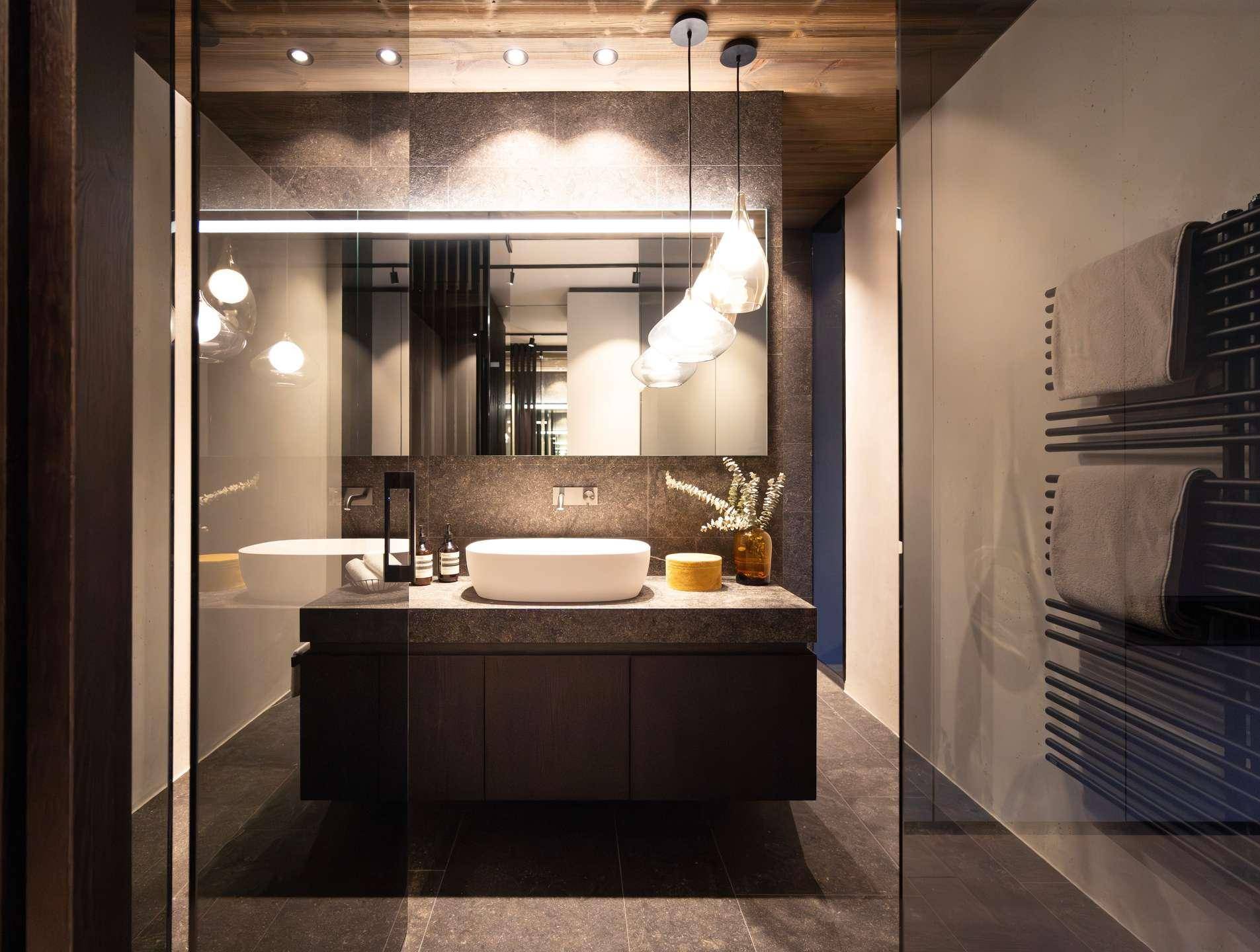 Elegantes Badezimmer mit modernem Waschtisch, großer Spiegelfläche und begehbarer Dusche.