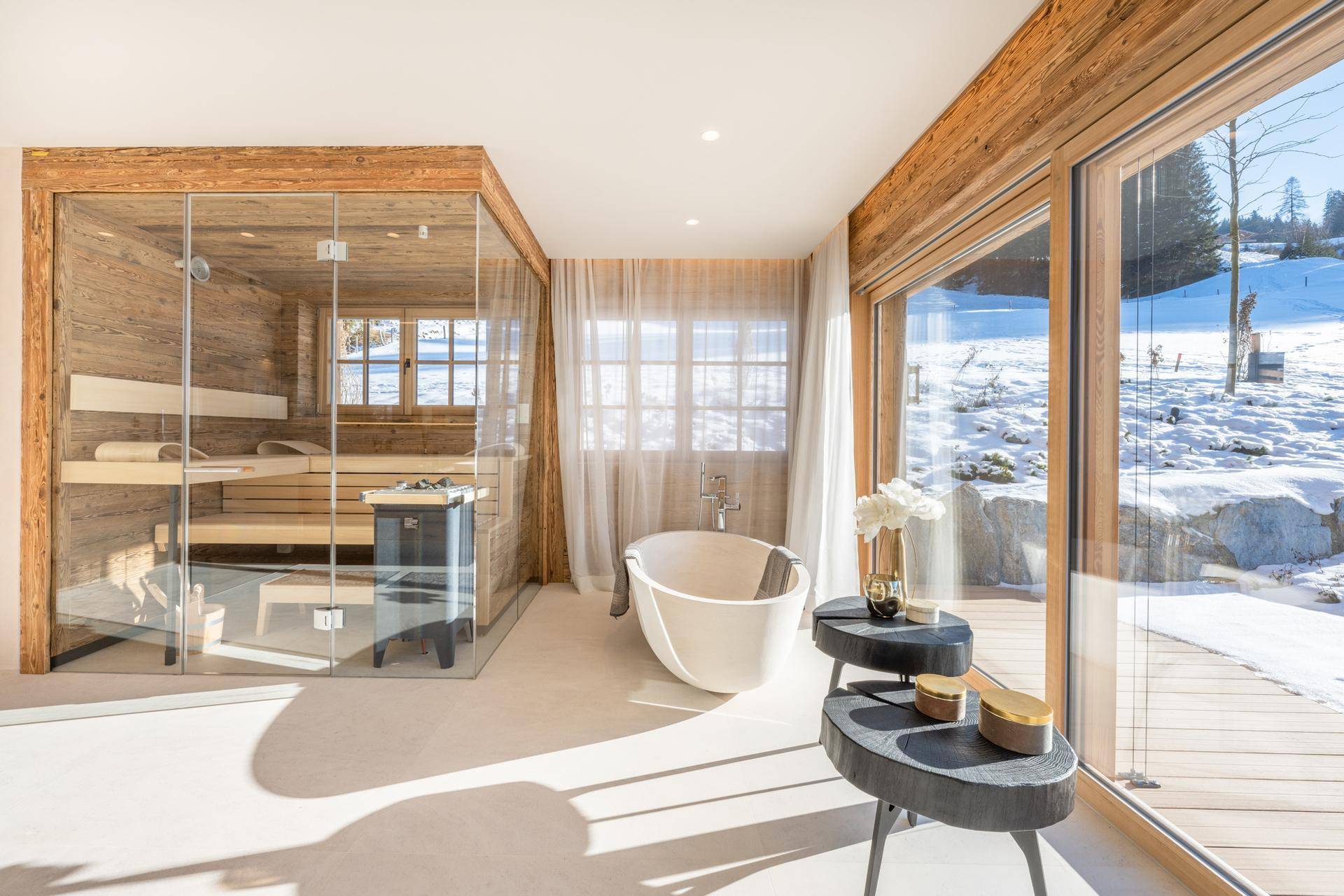 Exklusives Badezimmer mit integrierter Sauna, freistehender Badewanne und großzügigen Fenstern.