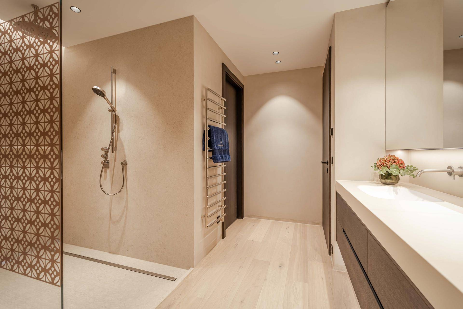 Elegantes Badezimmer mit begehbarer Dusche, Einzelwaschbecken und beheiztem Handtuchhalter.