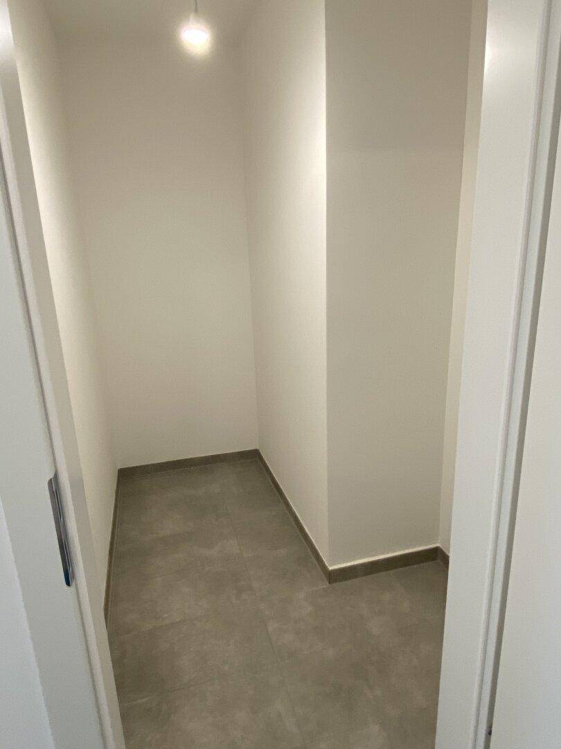 Praktischer Abstellraum mit Fliesenboden und weiß gestrichenen Wänden für zusätzlichen Stauraum.