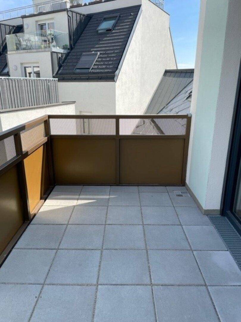 Geräumiger Balkon mit Fliesenboden und modernem Geländer, ideal zum Entspannen.