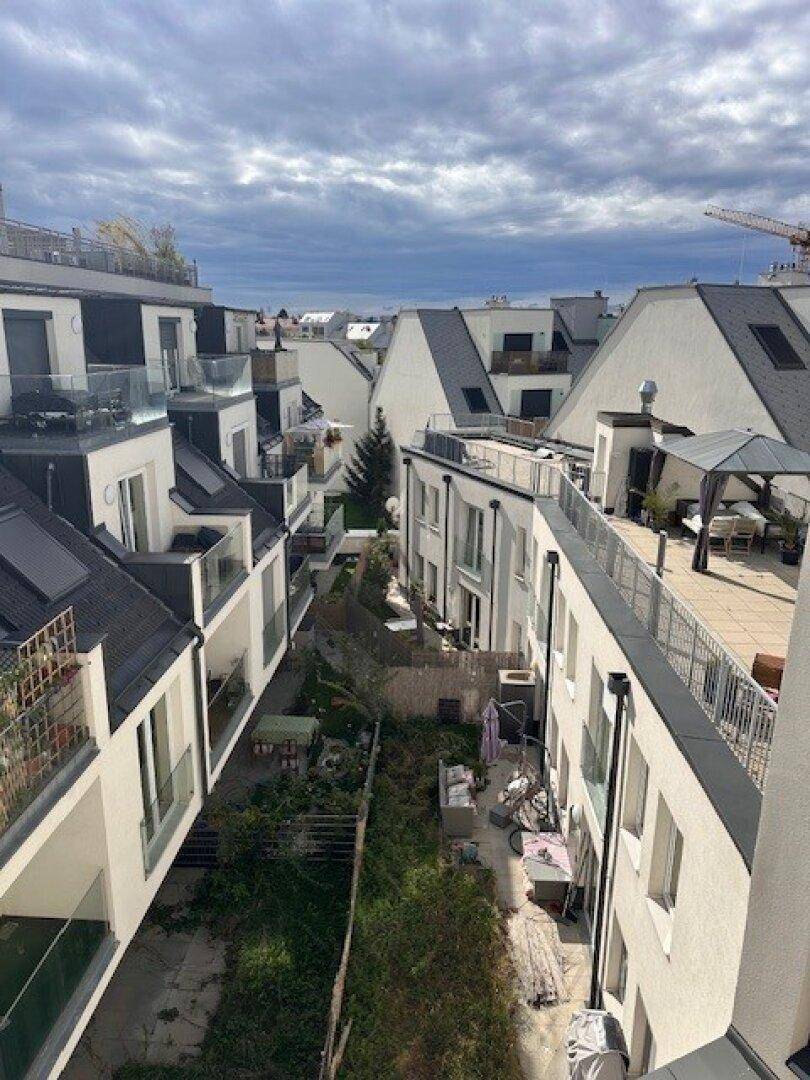 Überblick über eine moderne Wohnanlage mit mehreren Gebäuden, Balkonen und Dachterrassen.
