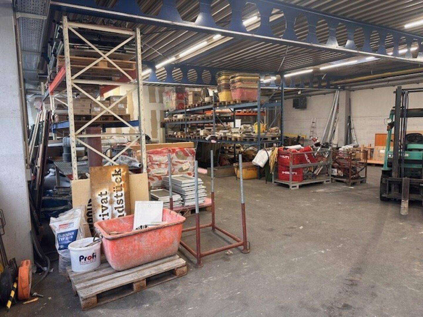 Geräumige Lagerhalle mit hohen Decken, Regalsystemen und verschiedenen Baumaterialien.