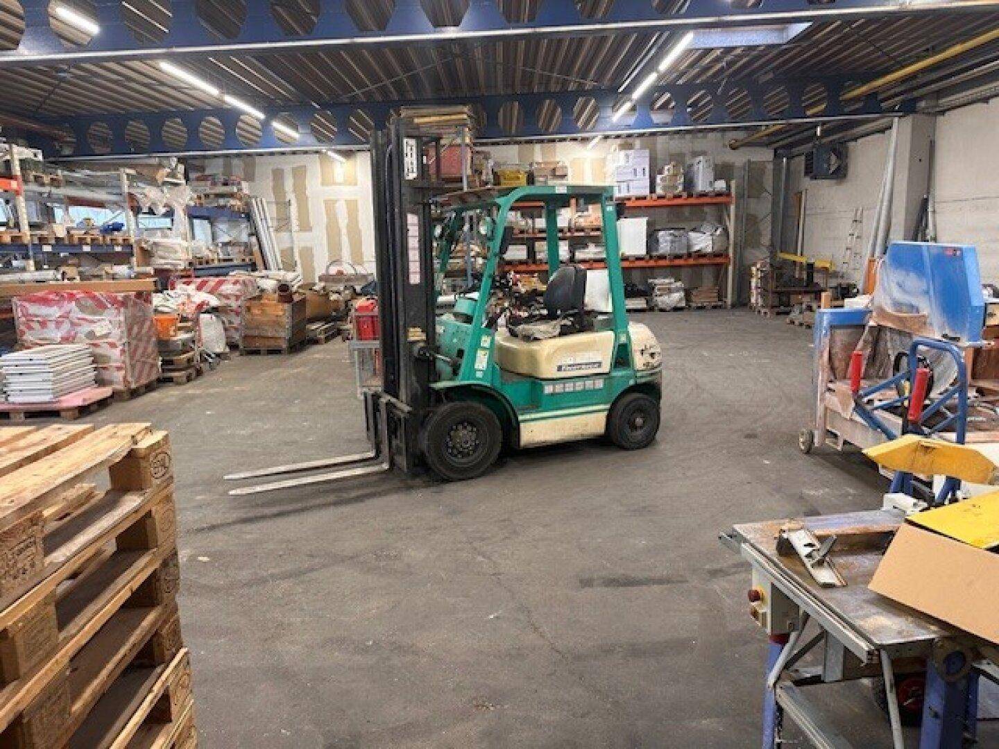 Gabelstapler in der Mitte einer Lagerhalle, bereit für den Transport von Gütern.