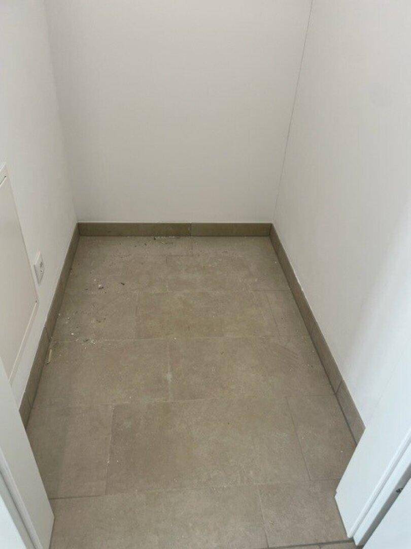 Kleiner, leerer Raum mit Fliesenboden und weißen Wänden, ideal als Abstellraum oder begehbarer Kleiderschrank.