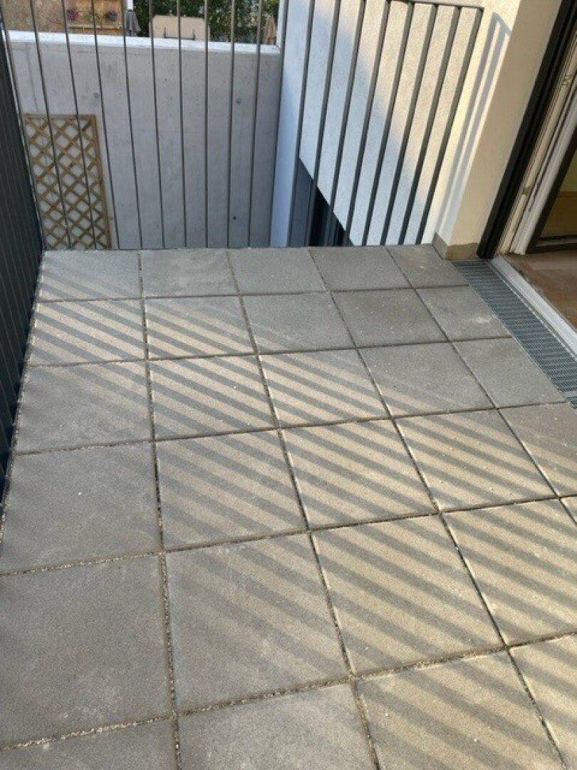 Gedeckter Balkon mit Fliesenboden und Metallgeländer, ideal für entspannte Stunden im Freien.