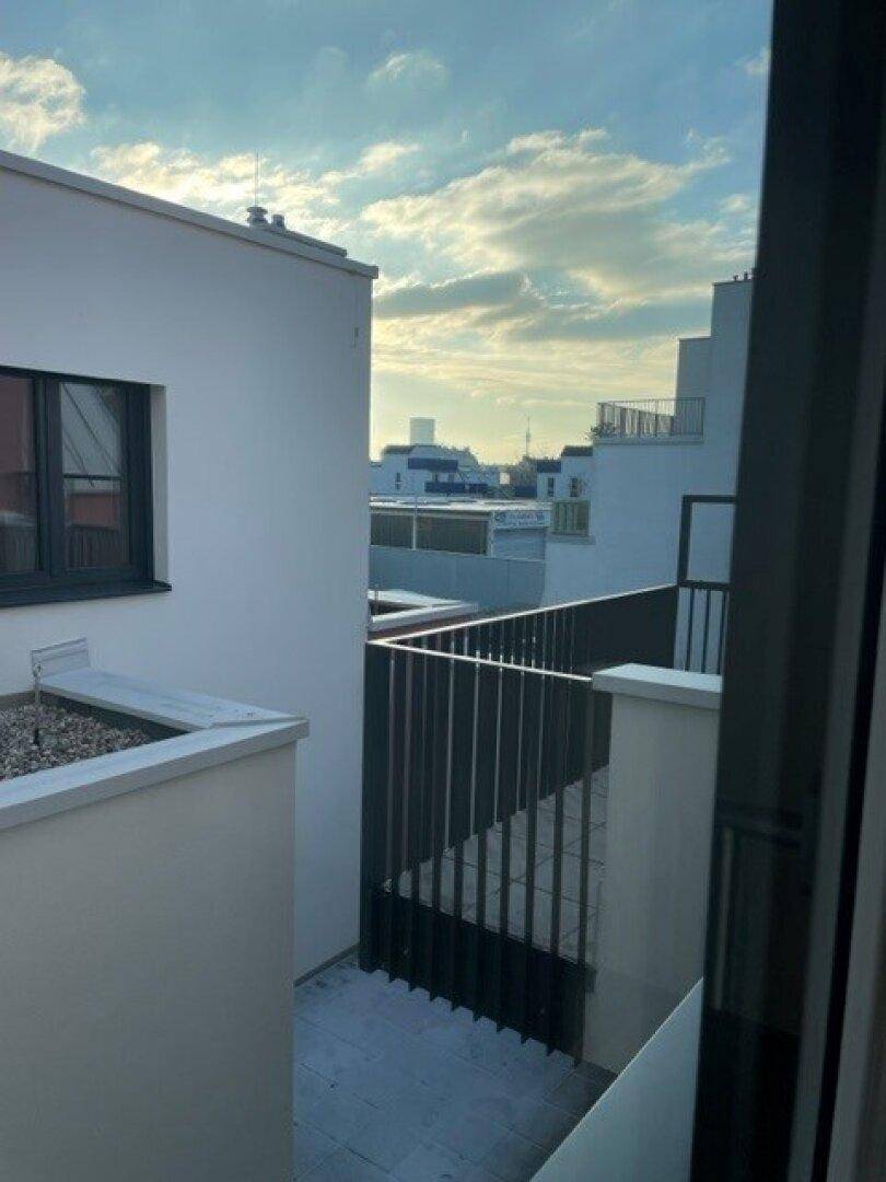 Blick von der Terrasse auf die umliegenden Gebäude und den Himmel.