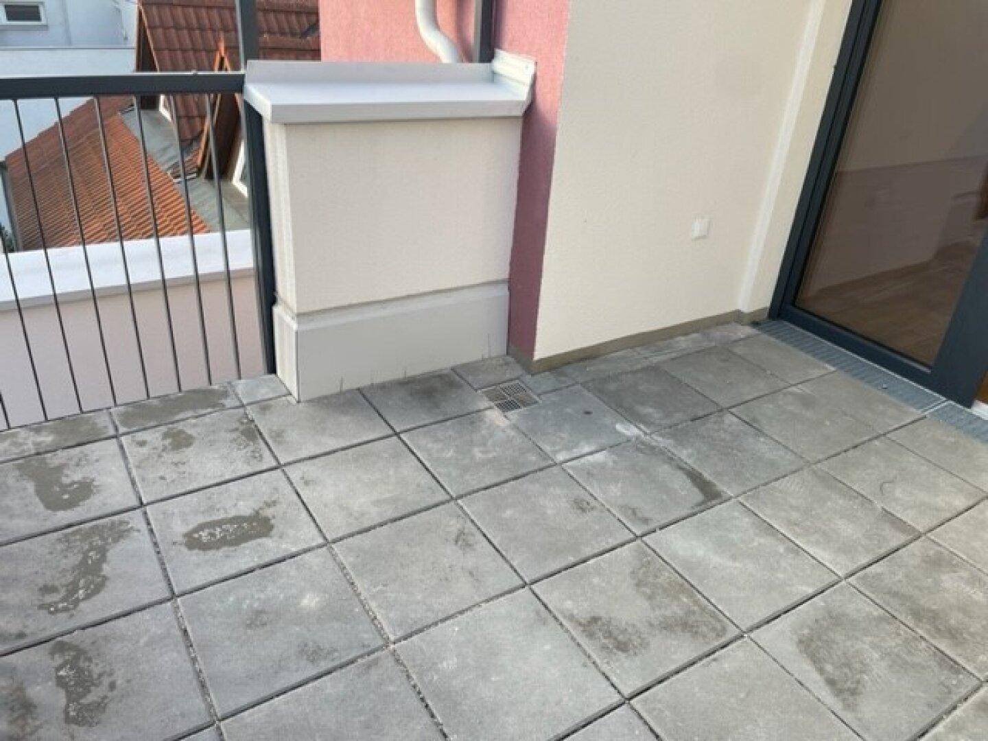 Detailansicht des Fliesenbodens und der niedrigen Brüstung auf der Terrasse.