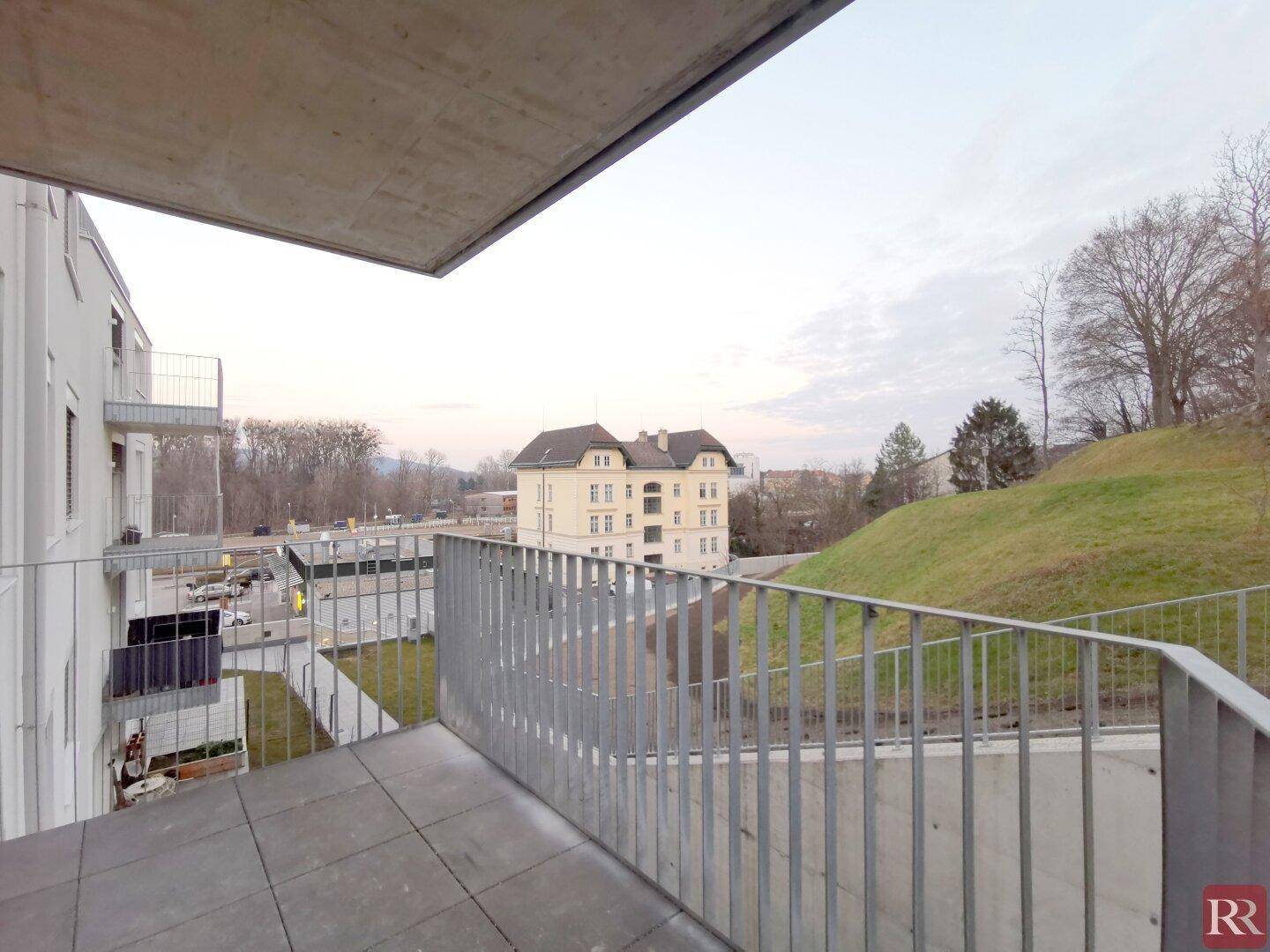 Geräumiger Balkon mit Metallgeländer und Blick auf die Umgebung und ein Gebäude.
