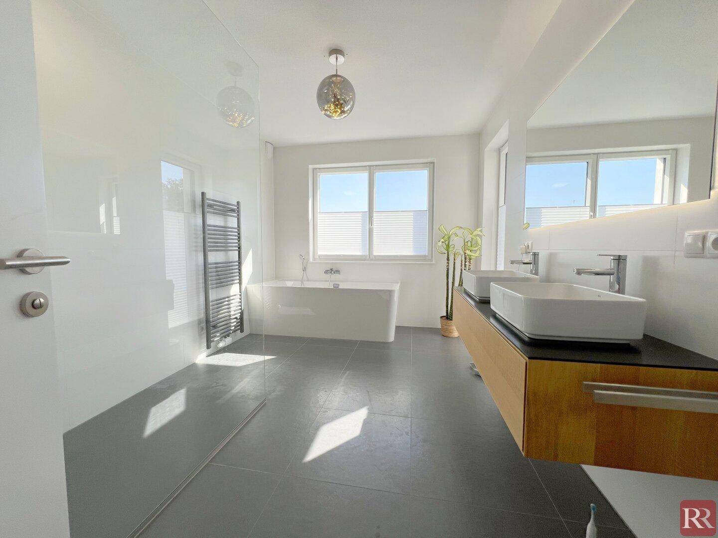 Modernes Badezimmer mit Doppelwaschbecken, freistehender Badewanne und großer Dusche.