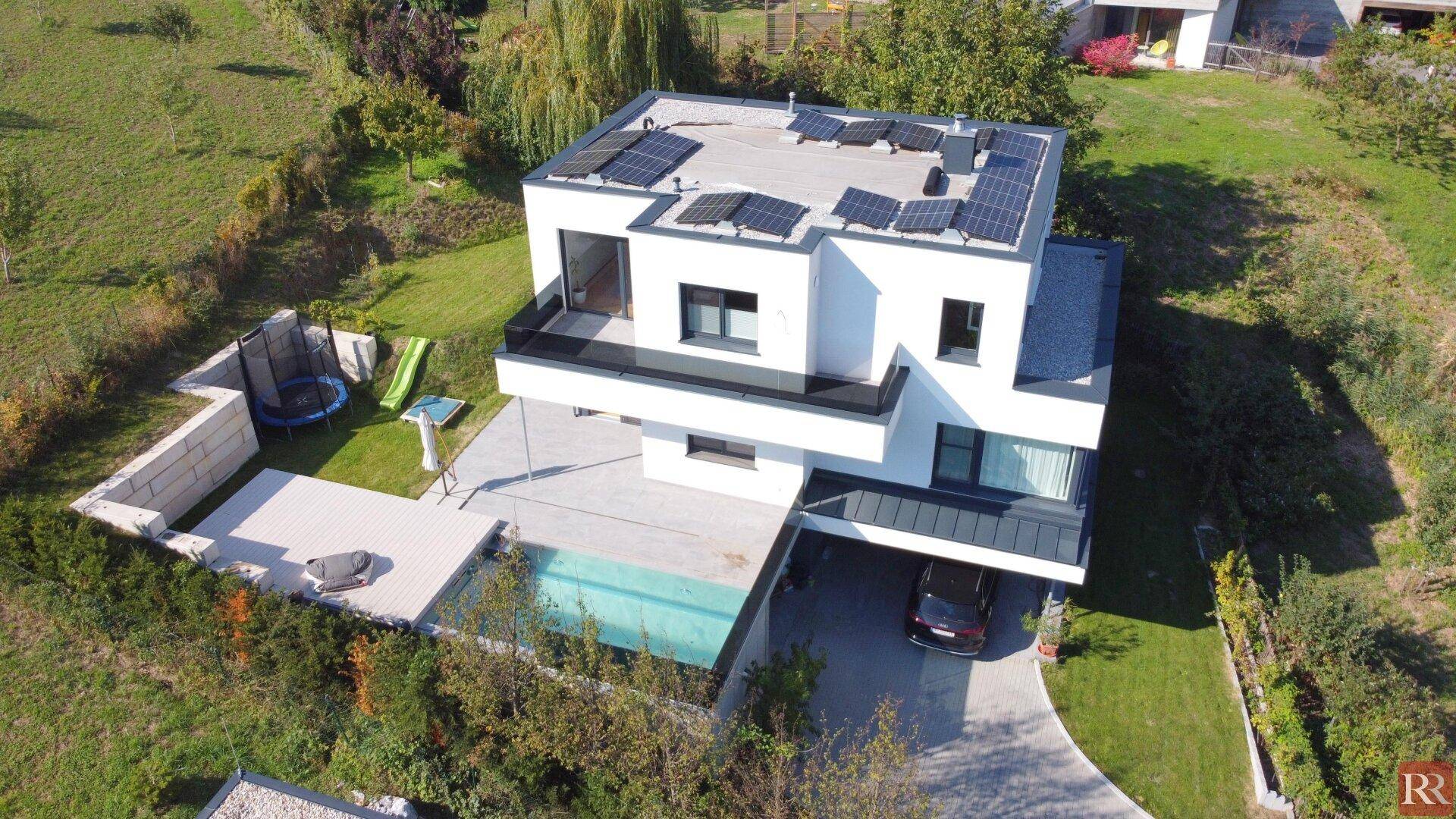 Luftaufnahme des modernen Hauses mit Pool, Photovoltaikanlage und Garten.