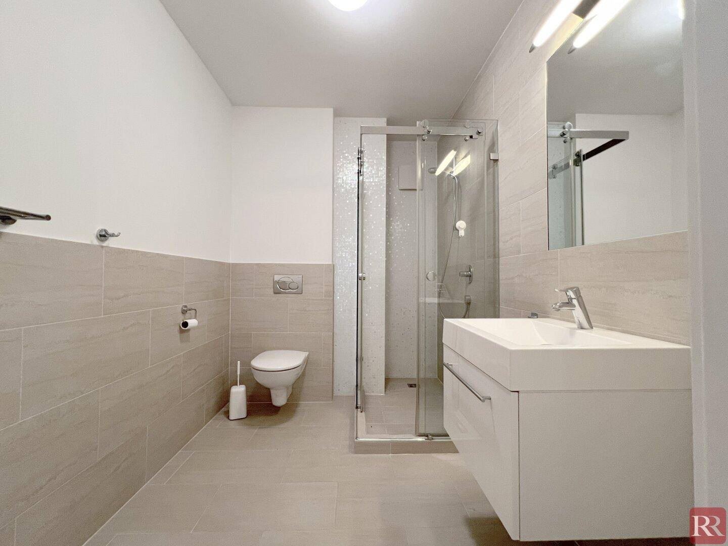 Modernes Badezimmer mit begehbarer Dusche, schwebendem Waschtisch und Wand-WC.