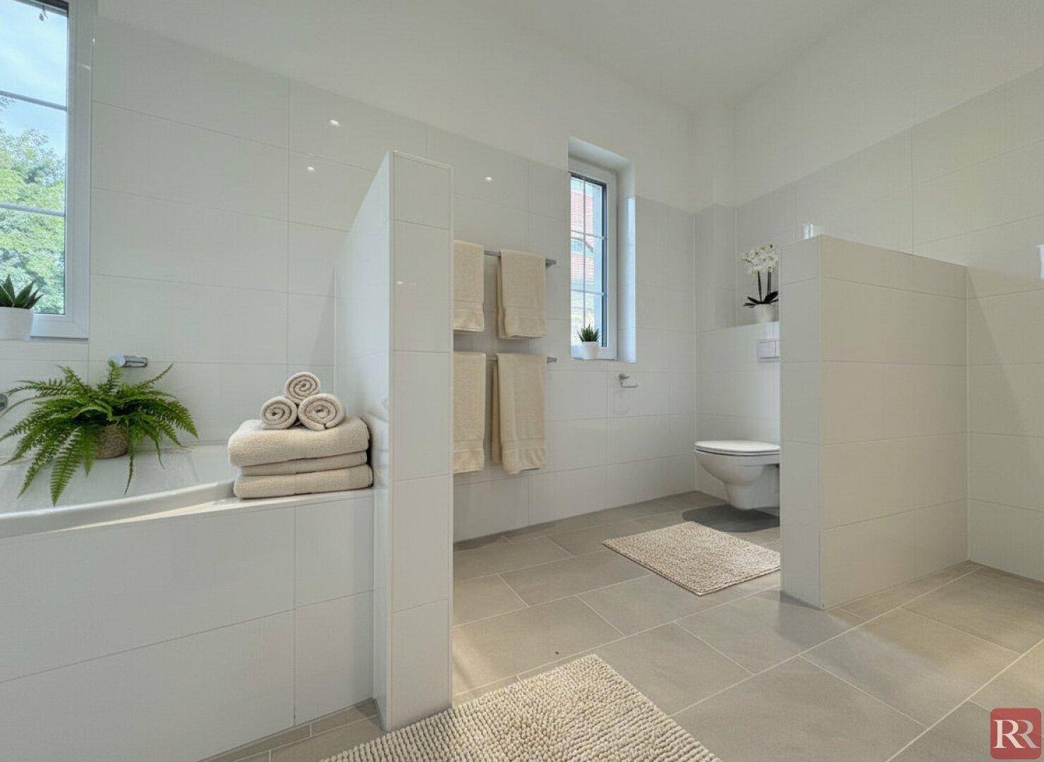 Helles Badezimmer mit Badewanne, wandhängendem WC und Fenster für Tageslicht.