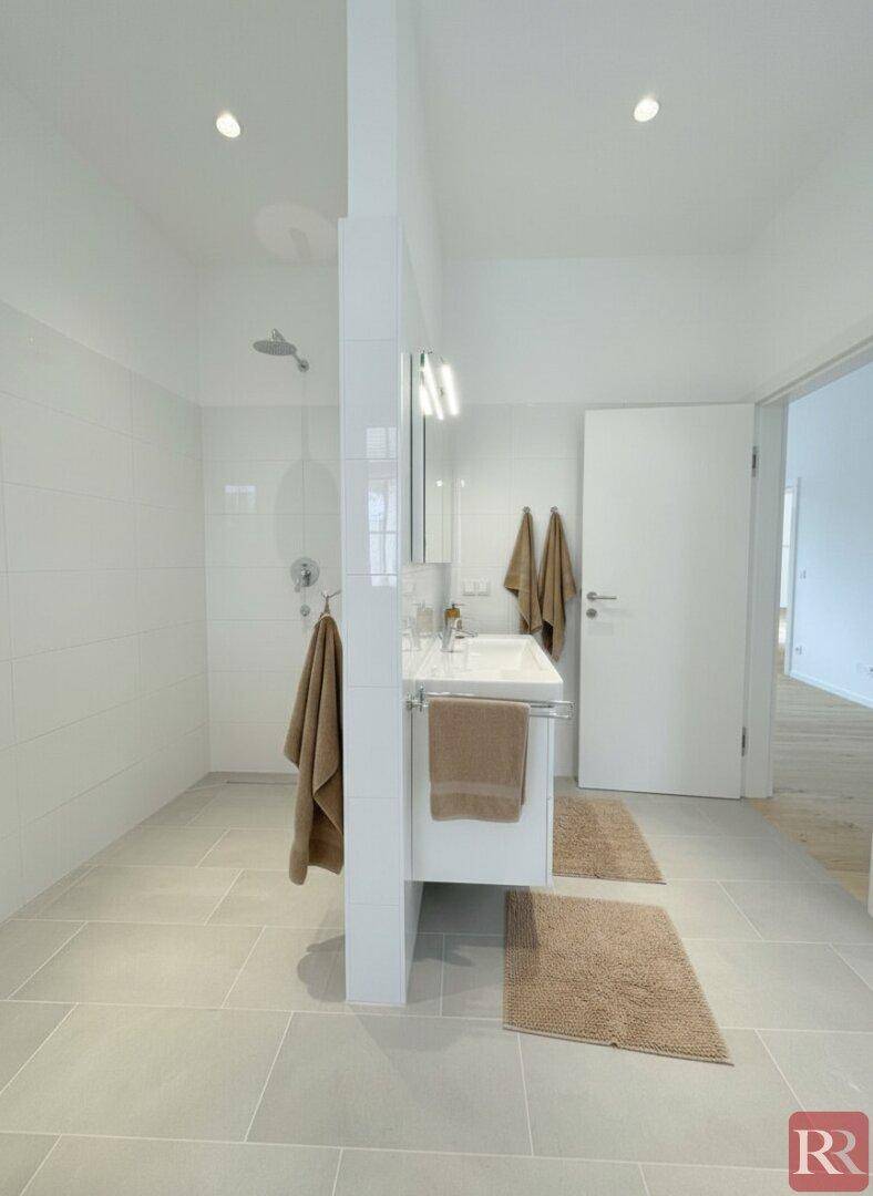 Modernes Badezimmer mit großer begehbarer Dusche und Einzelwaschbecken.