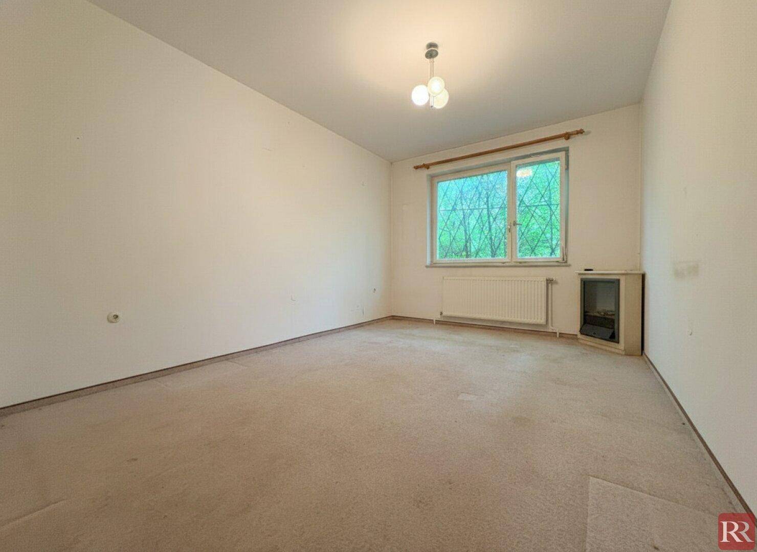 Schlafzimmer mit Teppichboden, Fenster und Heizkörper, bereit zur individuellen Gestaltung.