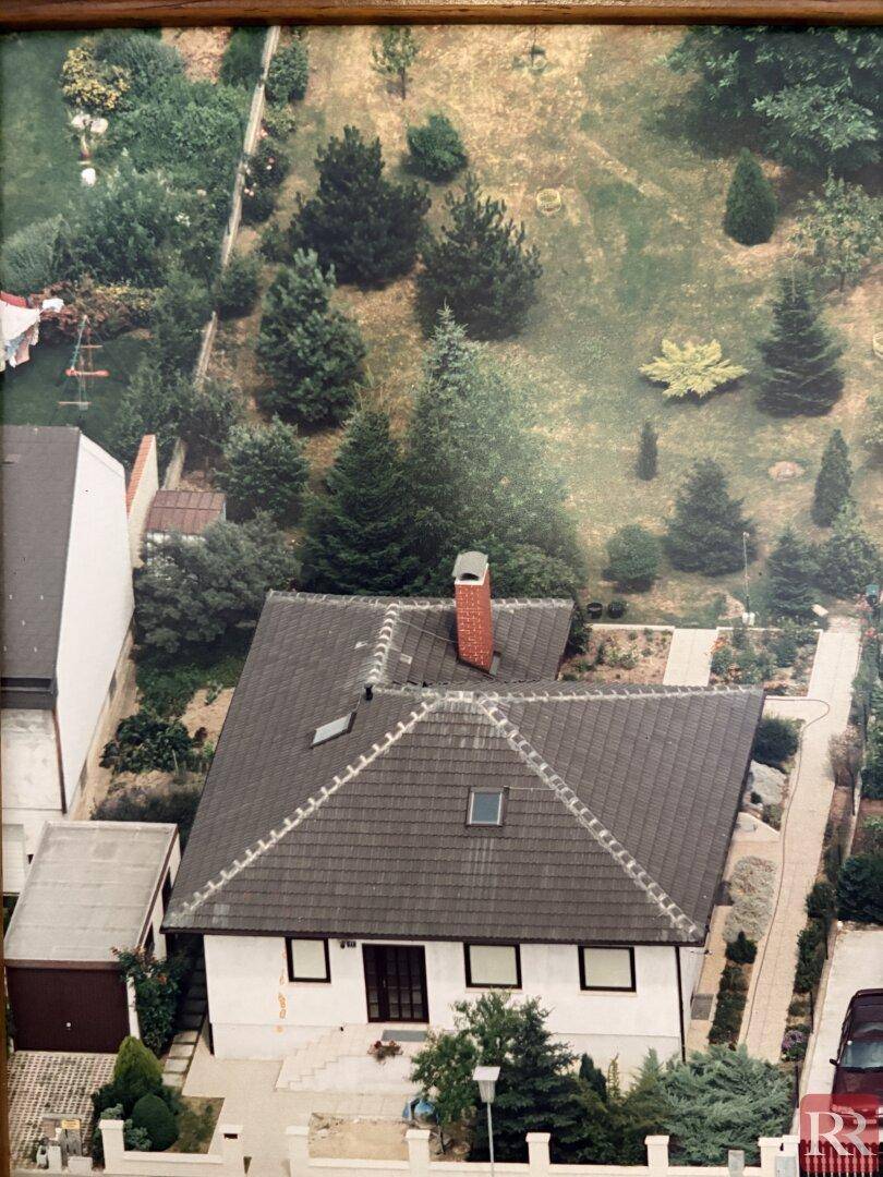 Luftaufnahme des Einfamilienhauses mit großem Garten und umliegender Bebauung.