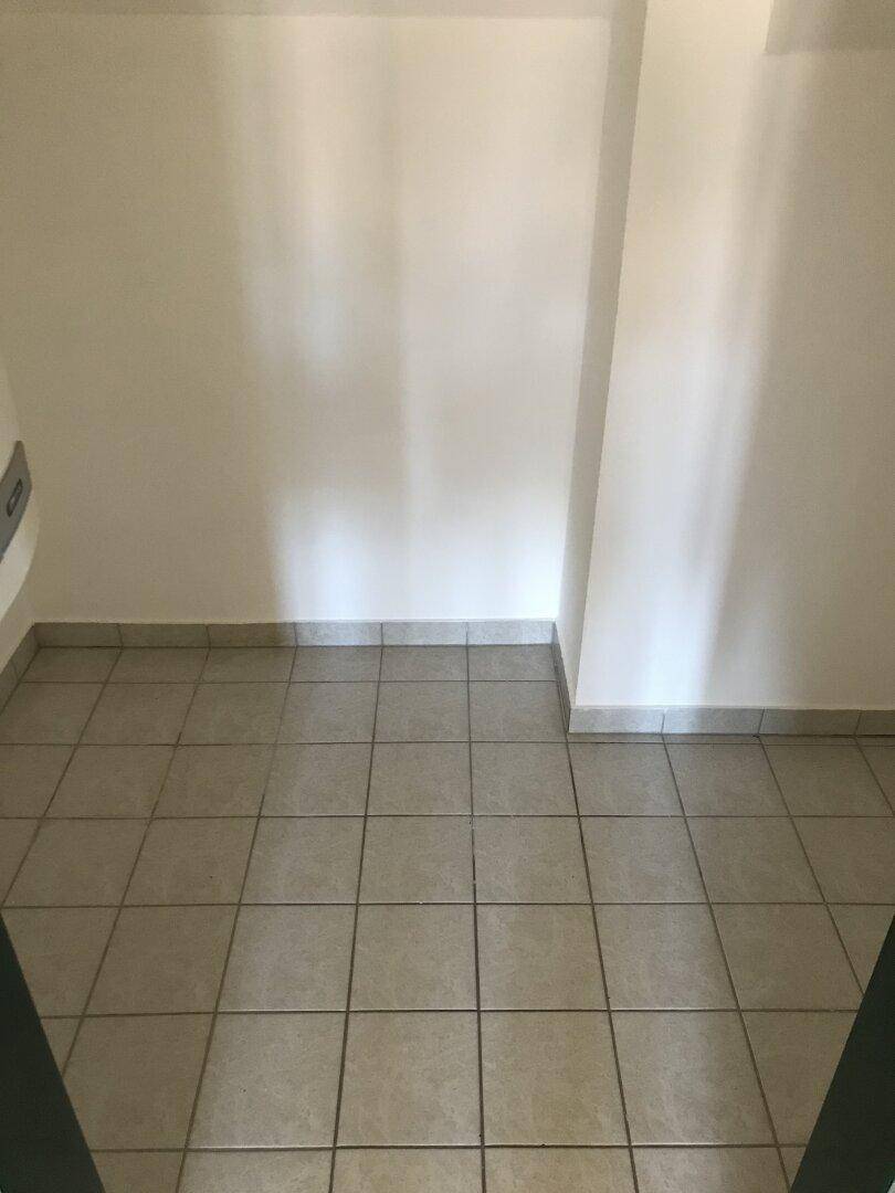 Kleiner Raum mit grauen Fliesen und weißen Wänden, ideal als Abstell- oder Hauswirtschaftsraum.