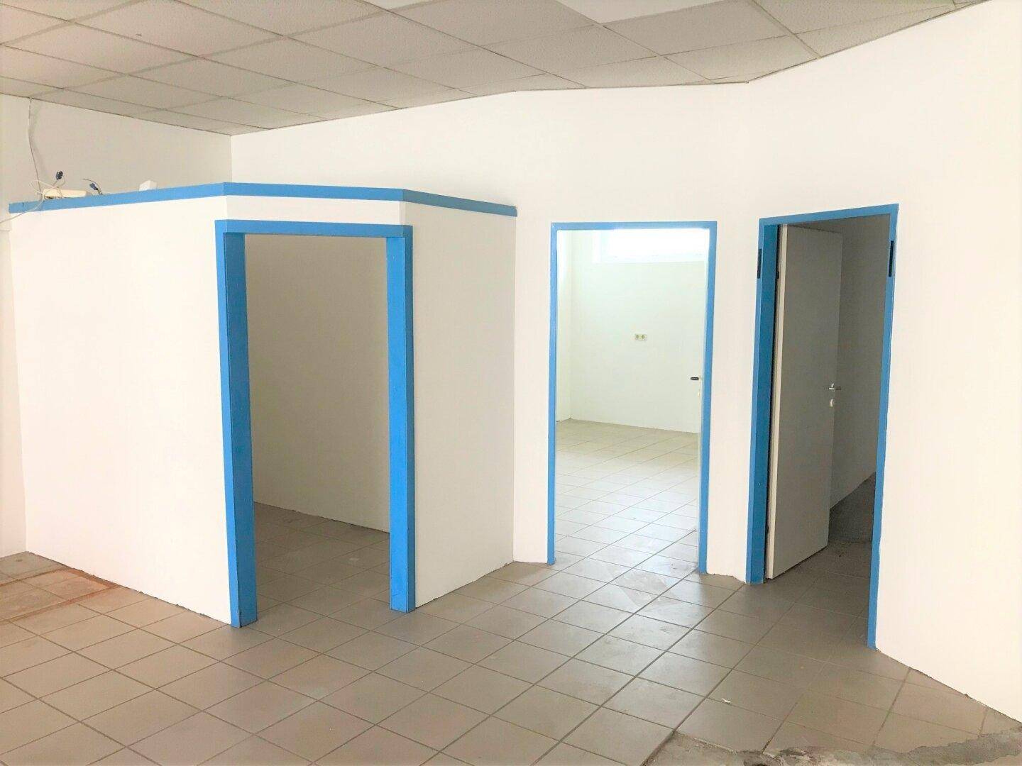 Detailansicht des leeren Raumes mit blauen Türrahmen und Fliesenboden, bereit für die Gestaltung.