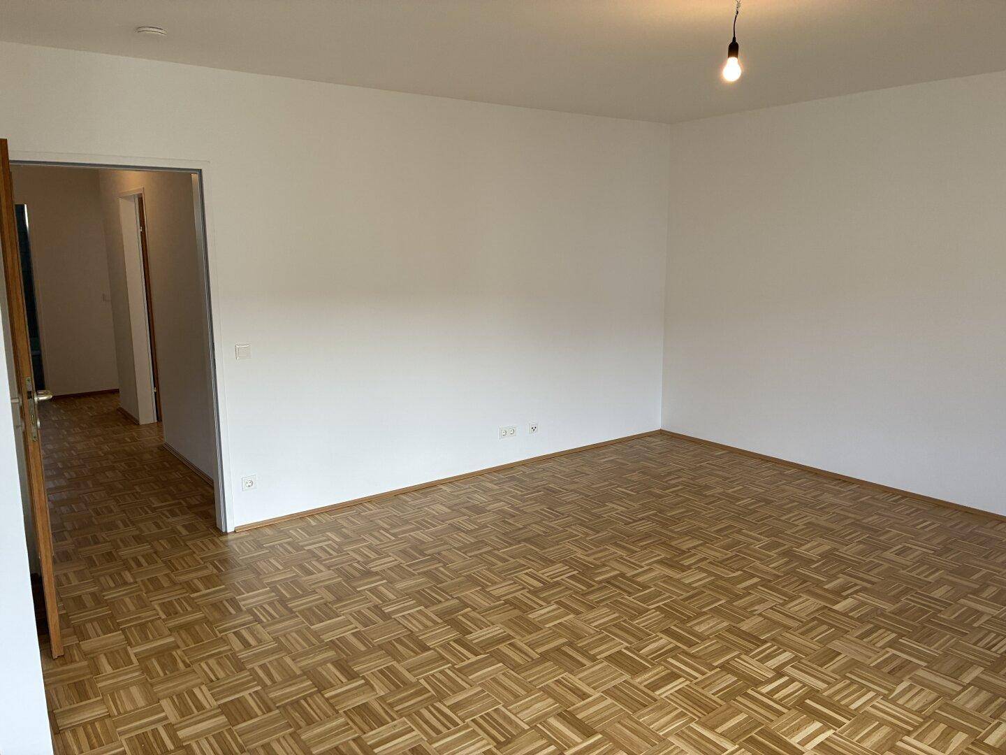 Geräumiger Wohnbereich mit Parkettboden und viel Platz für individuelle Gestaltung.