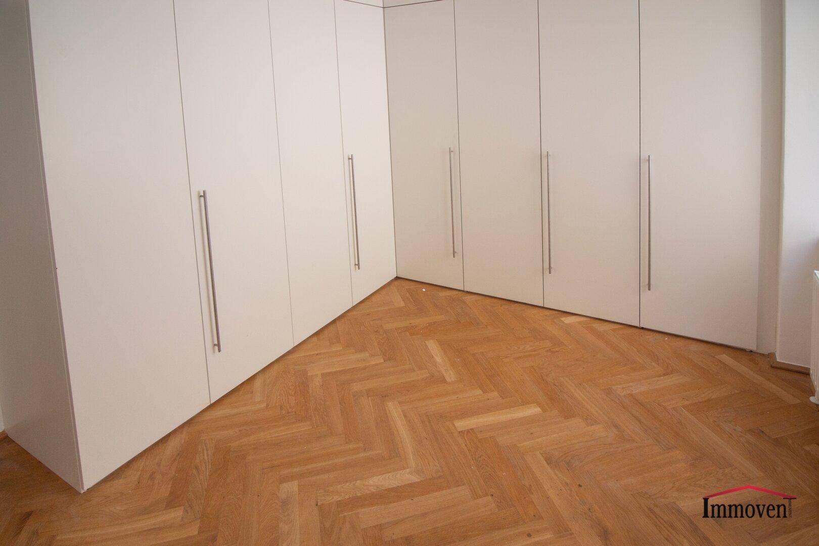 Schlafzimmer mit Einbauschränken und Fischgrätparkett, bietet viel Stauraum.