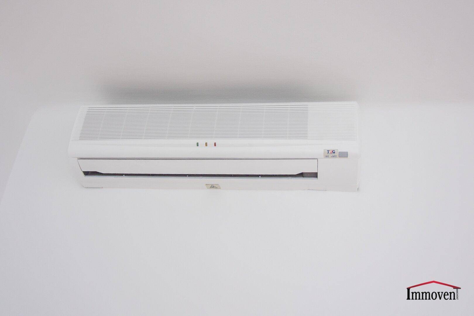 Eine weiße Klimaanlage ist an der Wand montiert und sorgt für angenehme Raumtemperatur.