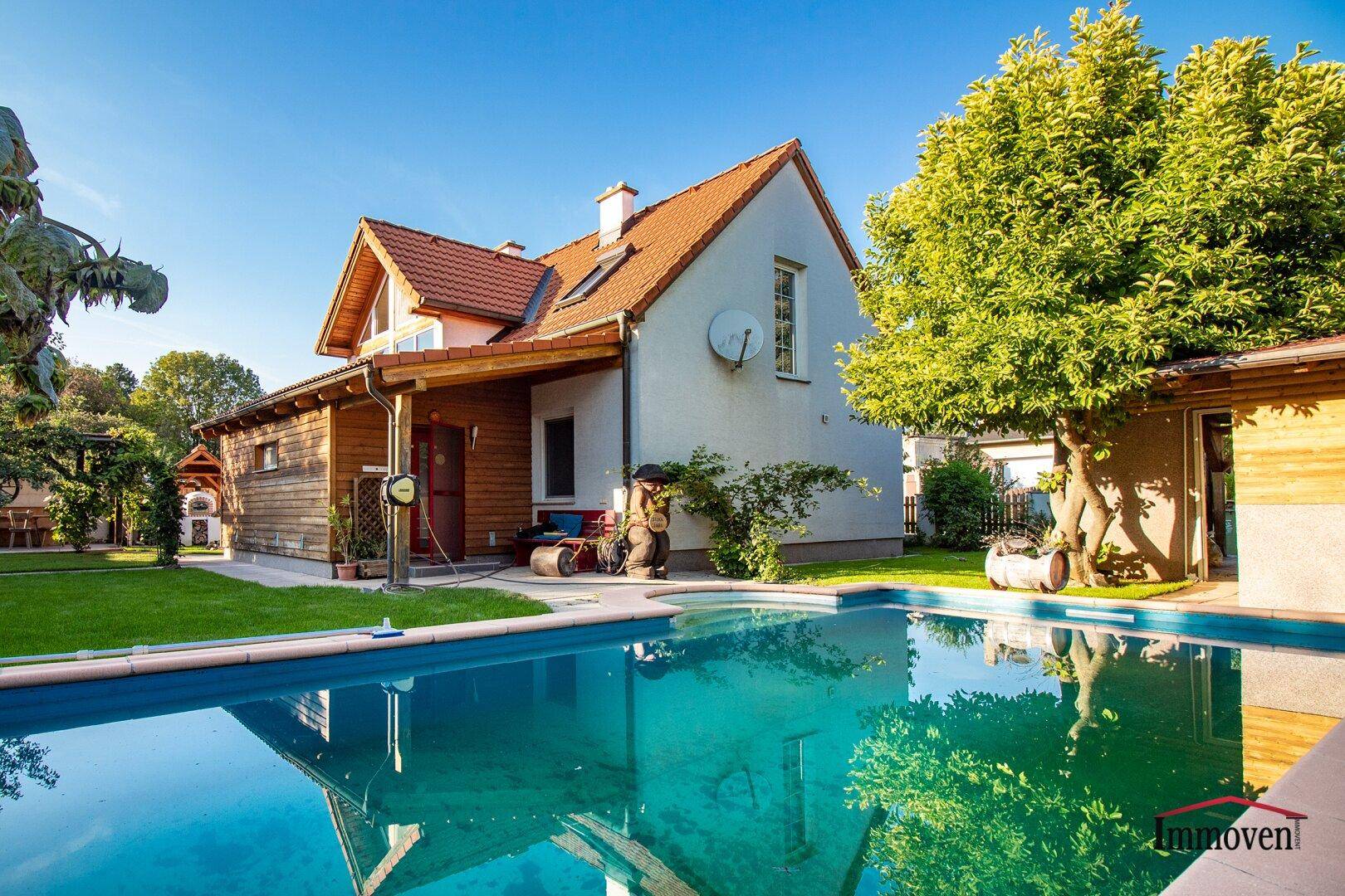 Großzügiger Gartenbereich mit Swimmingpool, Rasenfläche und dem Haus im Hintergrund.
