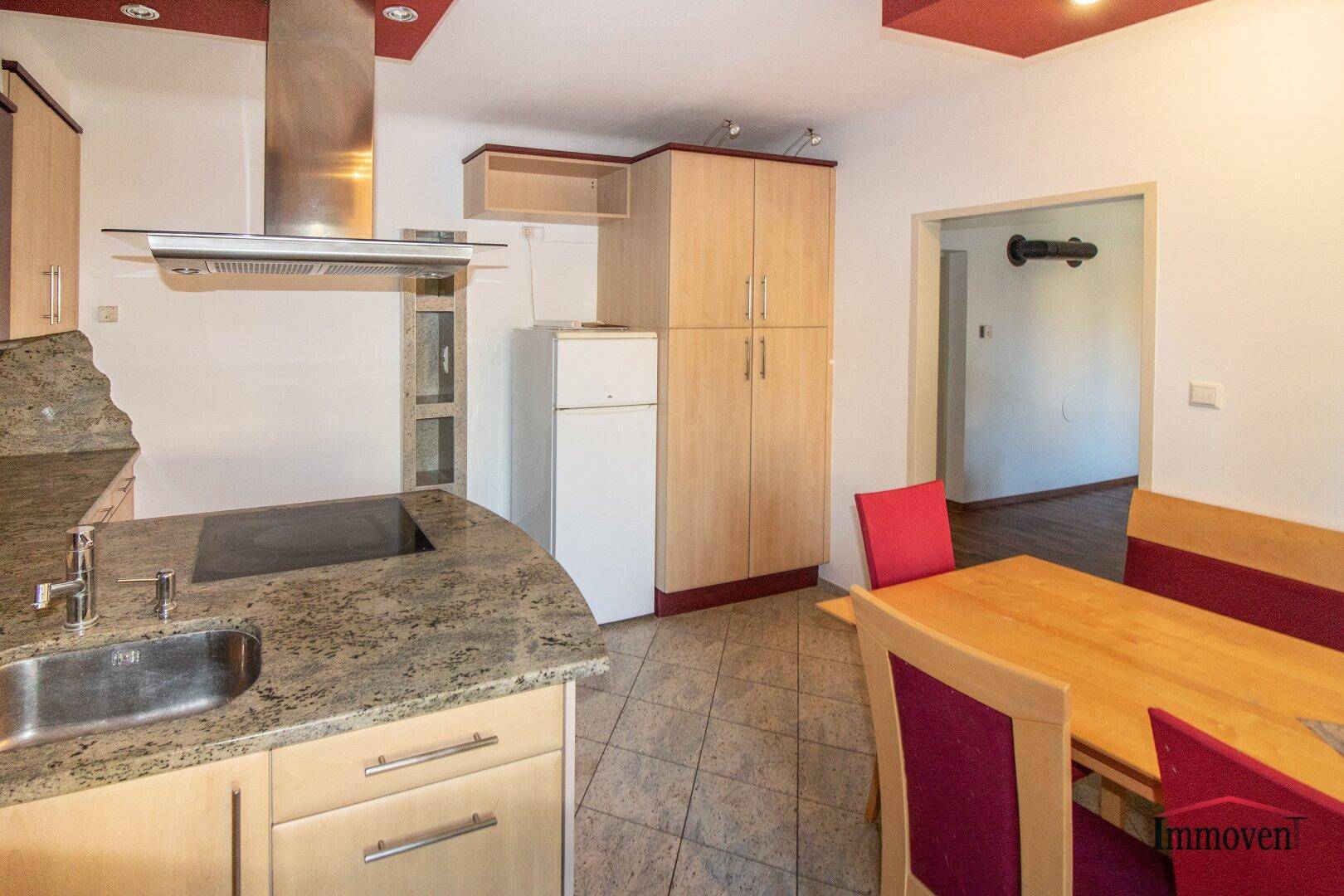 Geräumige Wohnküche mit Essbereich, Granitarbeitsplatten und Kühlschrank.