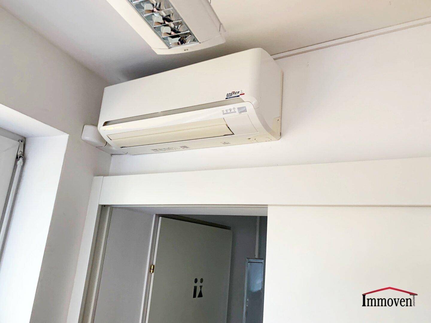 Nahaufnahme einer Klimaanlage an der Decke in einem modernen Büroraum.