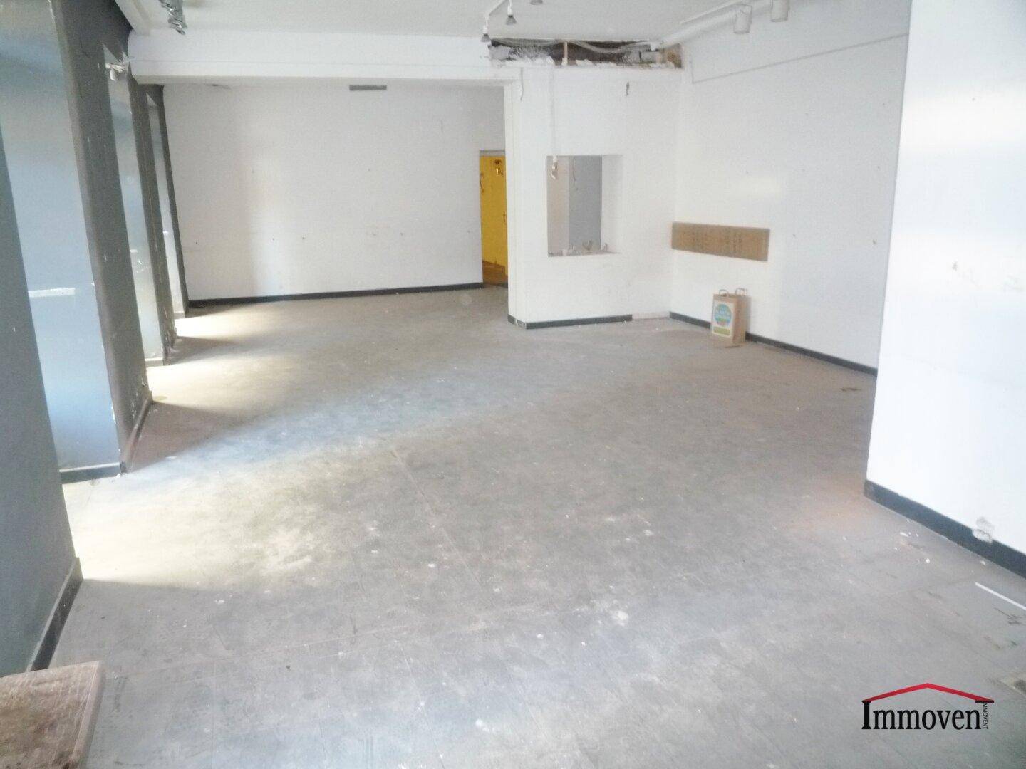 Leerstehender Gewerberaum mit Renovierungsbedarf, sichtbaren Wänden und einfacher Ausstattung.