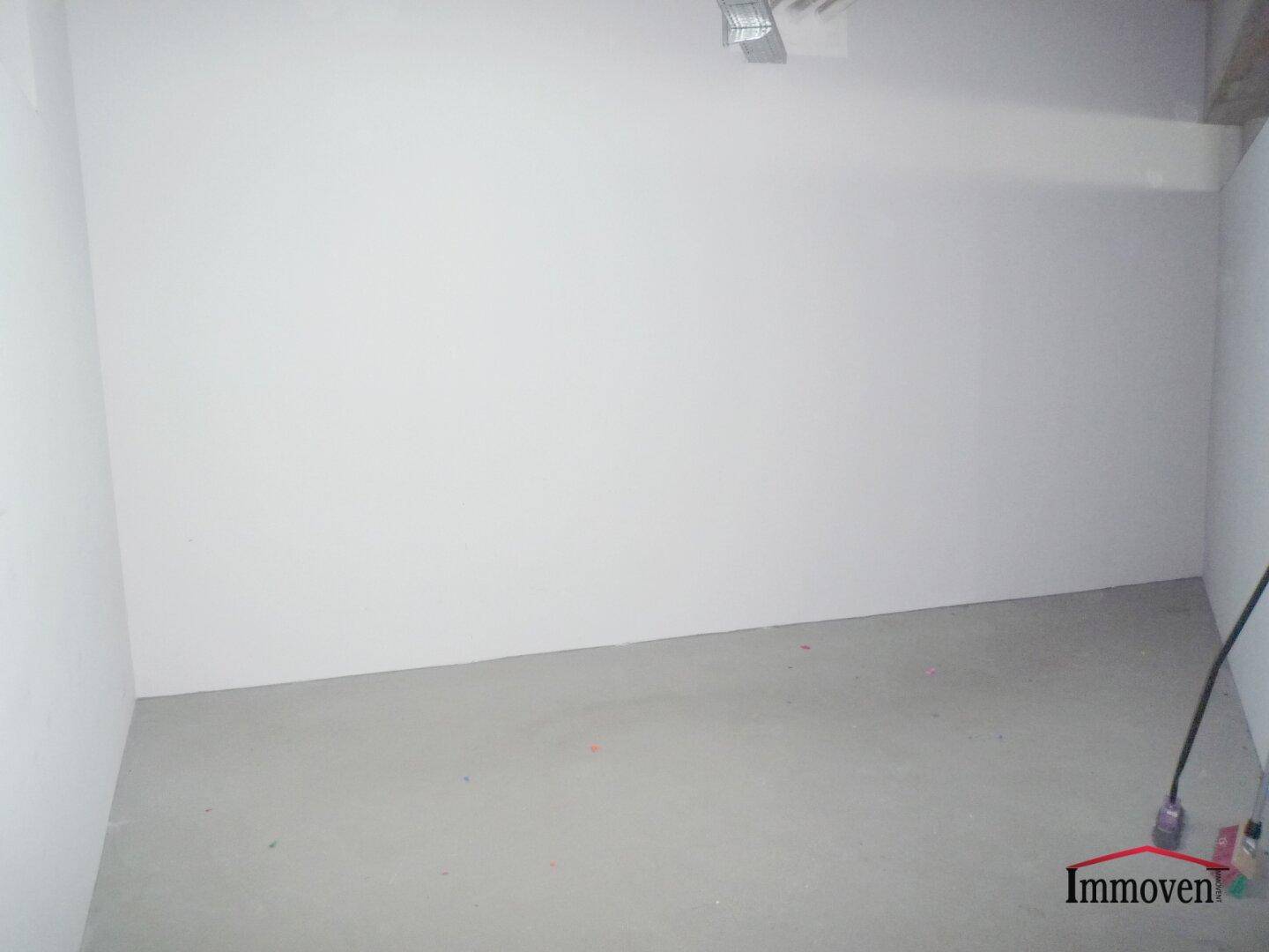 Kleinerer, heller Raum im Rohbau mit Betonboden und weißen Wänden, Teil eines Gewerbeobjekts.
