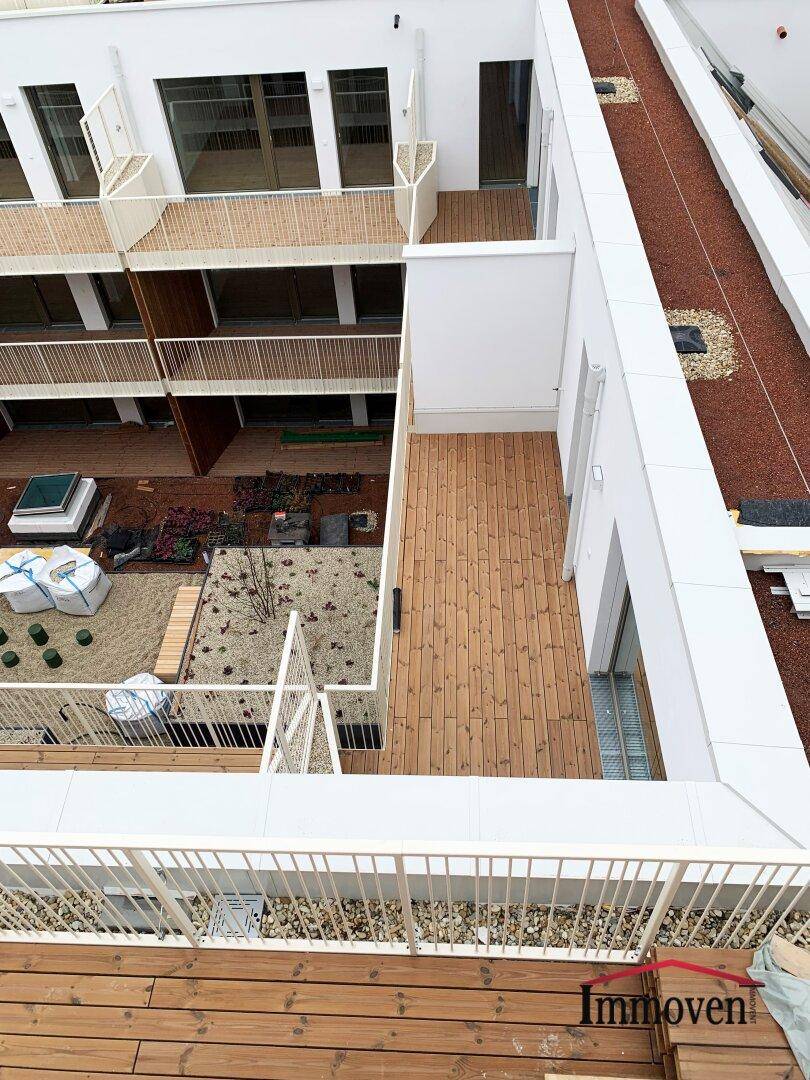 Dachterrassen und Gartenbereiche eines modernen Wohnkomplexes von oben gesehen.