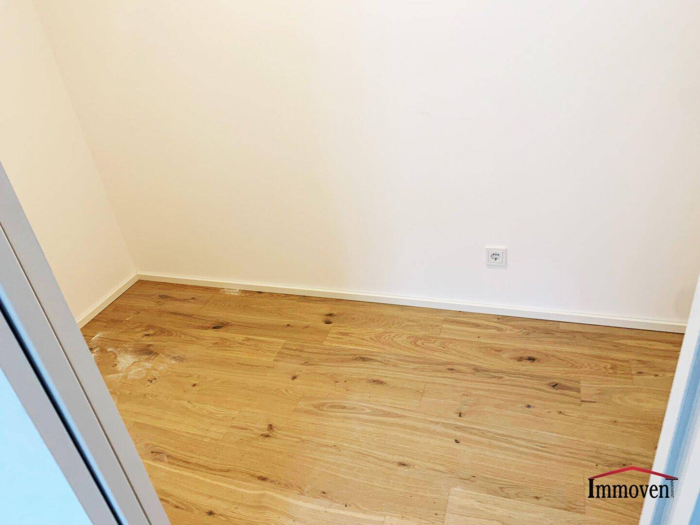 Kleiner Abstellraum mit Holzboden, ideal für zusätzlichen Stauraum und Haushaltsgeräte.