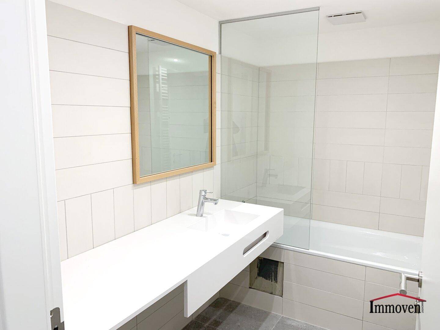 Modernes Badezimmer mit Badewanne, Duschabtrennung und schwebendem Waschtisch.