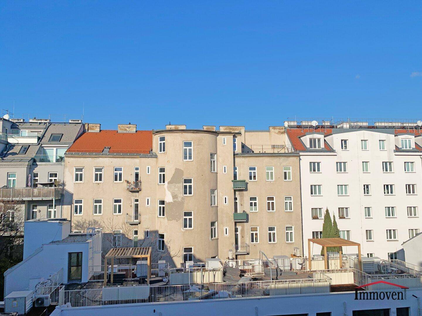 Blick auf die Rückseite eines Gebäudekomplexes mit verschiedenen Fassaden und Dächern.