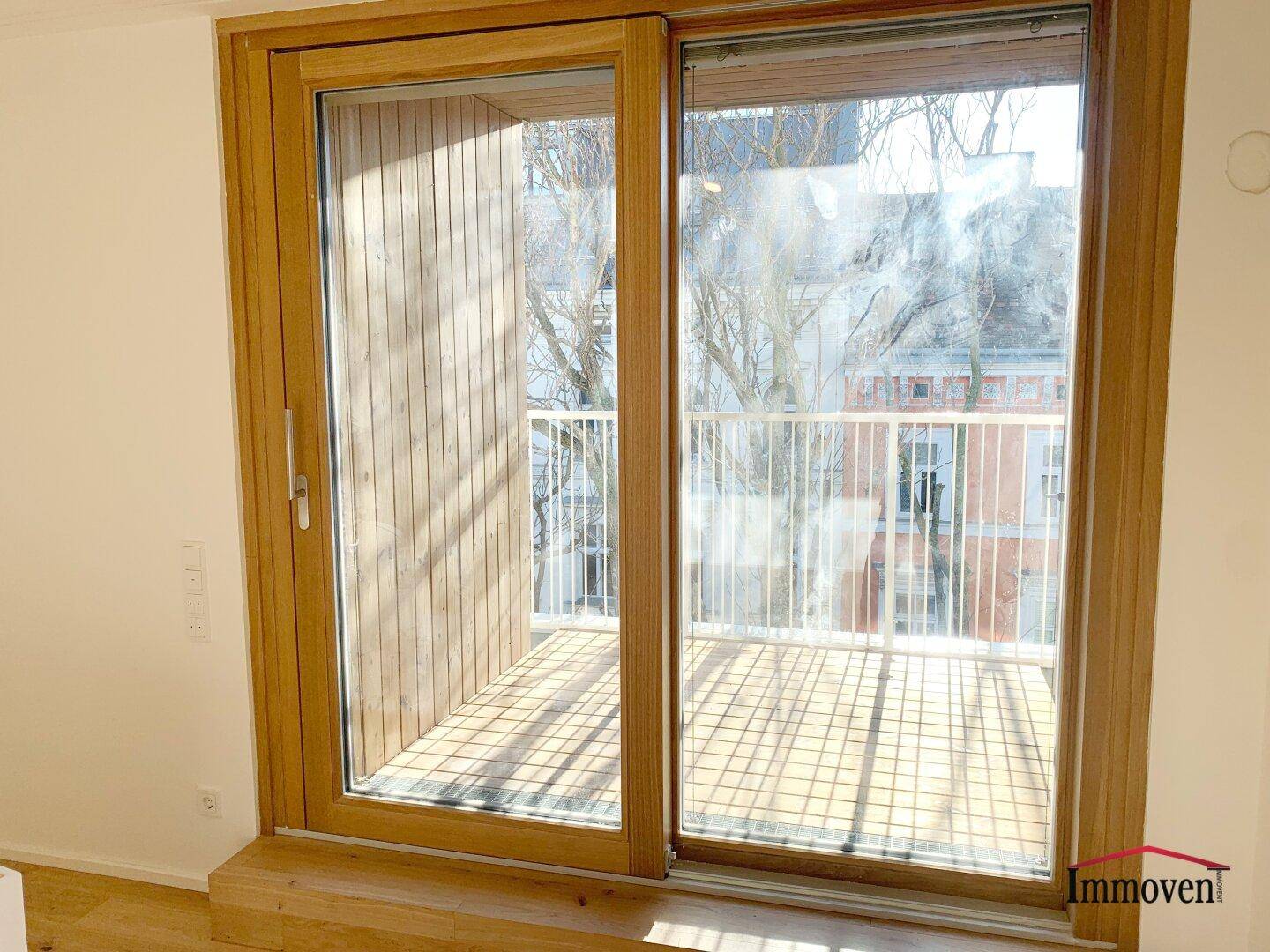Nahaufnahme eines Balkons mit Holzboden und Blick auf die Umgebung.